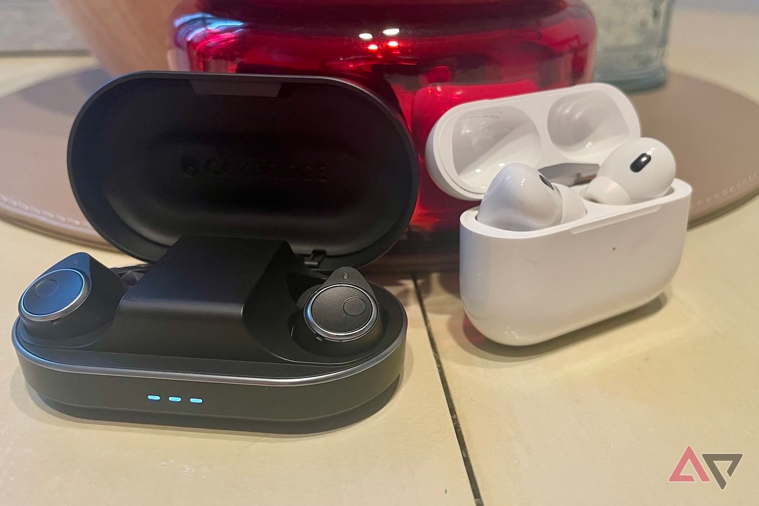 Cambridge Audio Melomania M100 headphones next to AirPods Pro 2nd generation with Lightning.