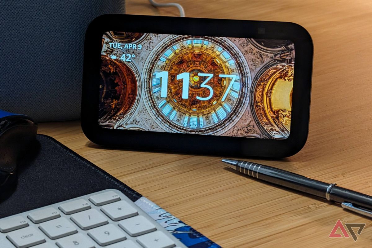 The Echo Show 5 (3rd Gen) resting on a desk with a pen, keyboard, and mouse.