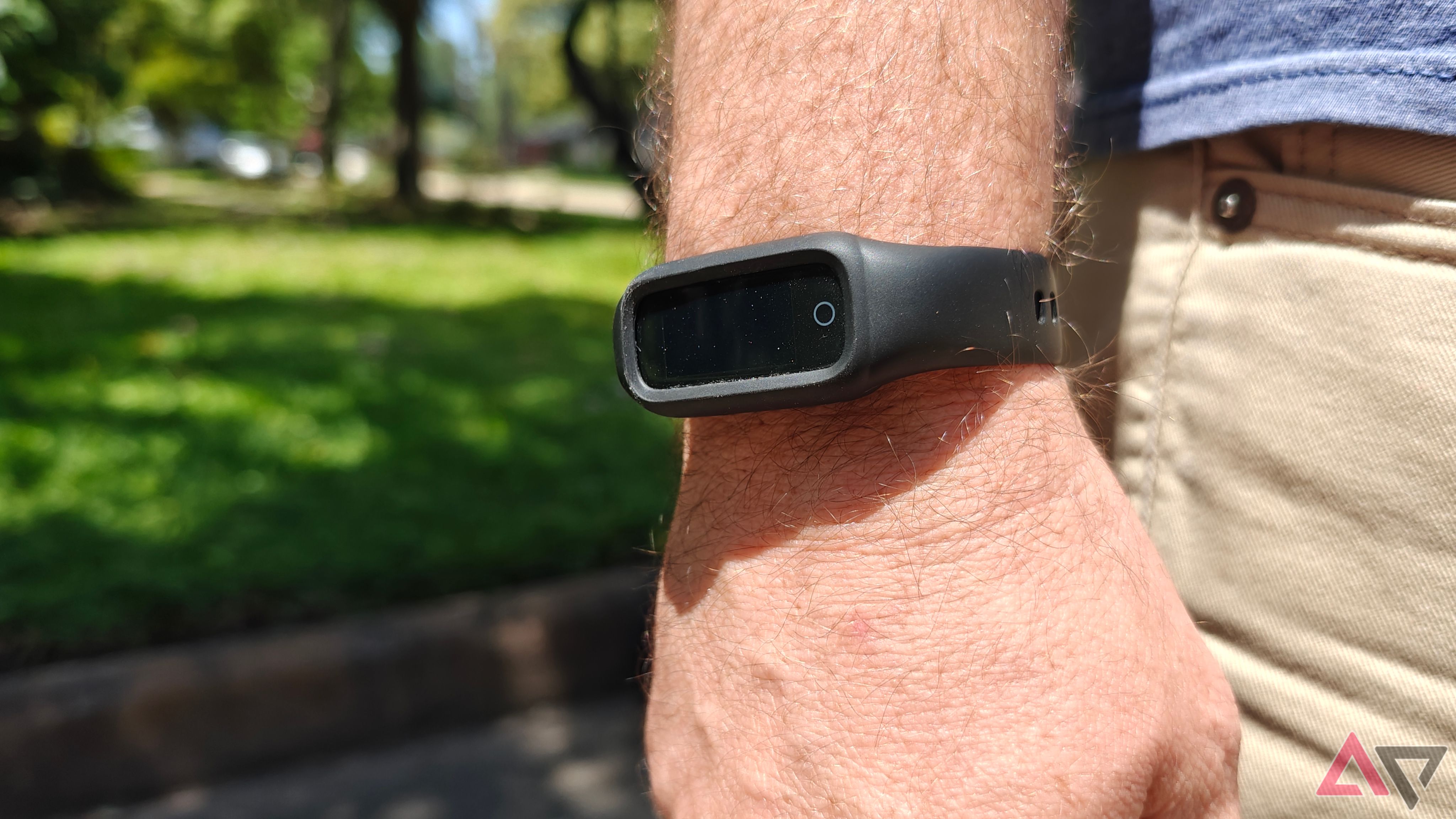 Black fitness band on wrist in front of grass lawn