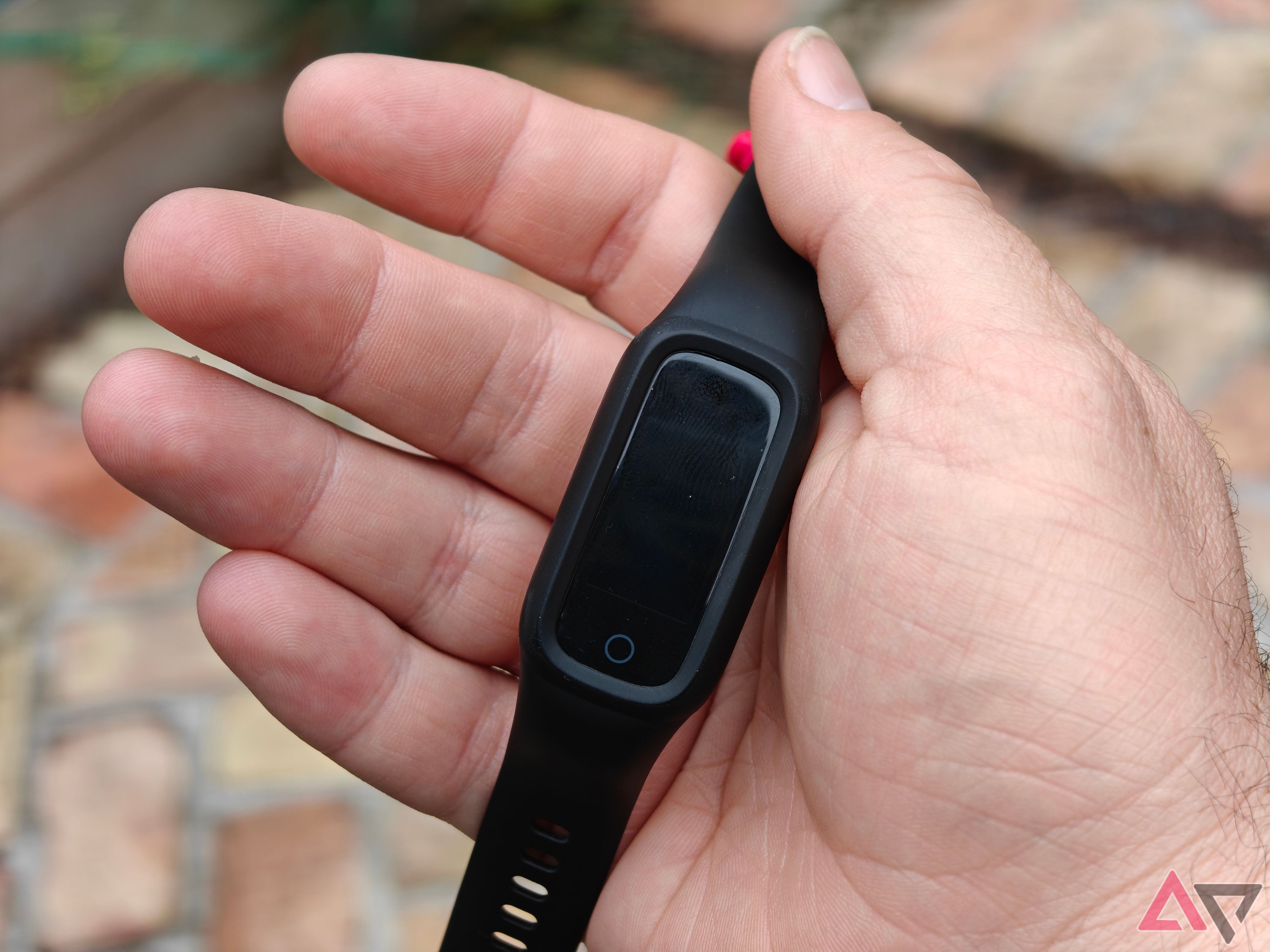 Fitness tracker held in open hand outside