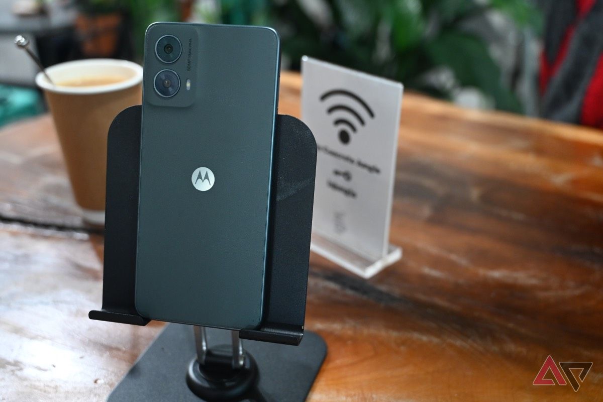 Back shot of the Moto G 5G on a wood table with cup of coffee in background