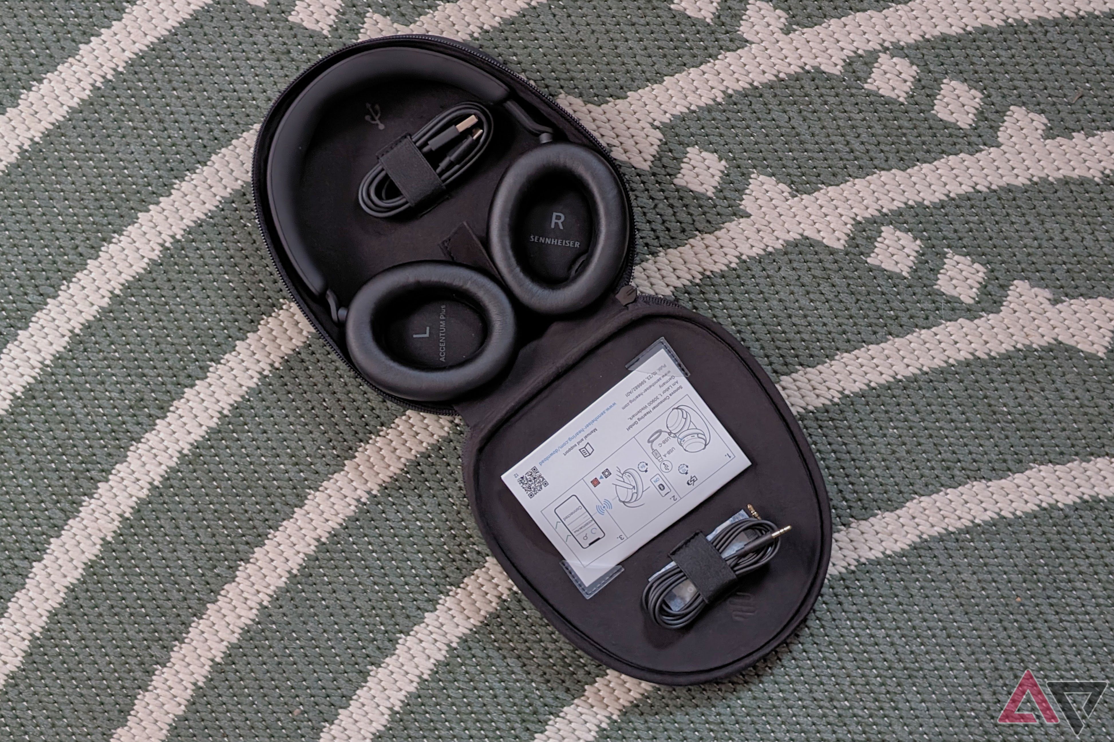 A pair of headphones in their case on a green rug