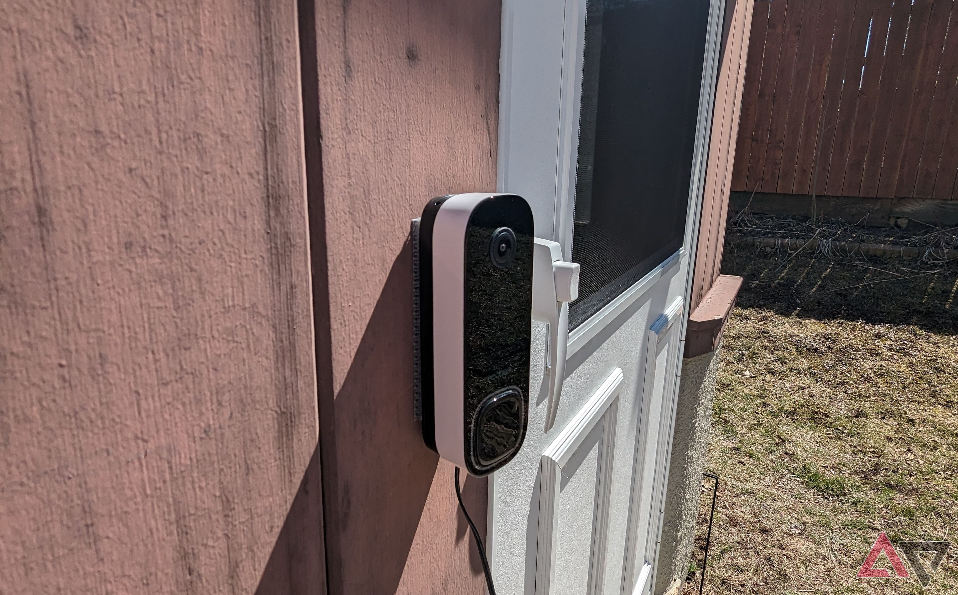 Far left angle of Ecobee Smart Doorbell Camera (Wired) mounted on wall next to white patio door