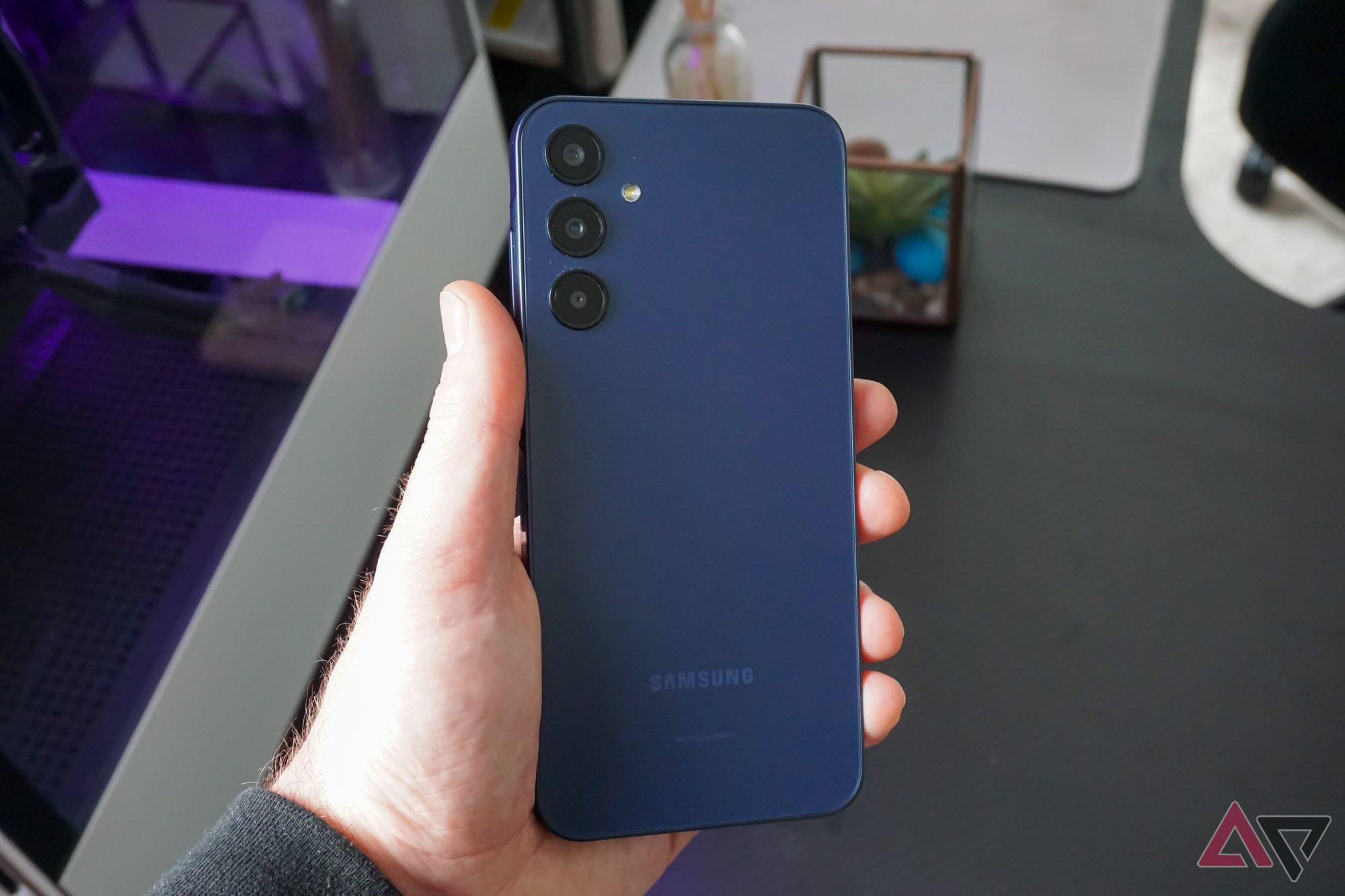 The Galaxy A25 held face down in a hand.