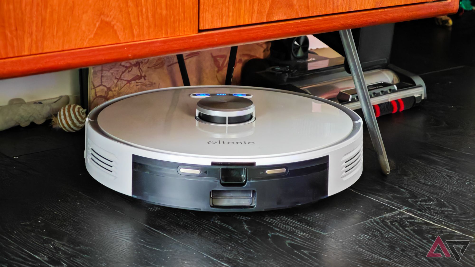 The Ultenic T10 Pro robot vacuum cleaning under a wooden cabinet