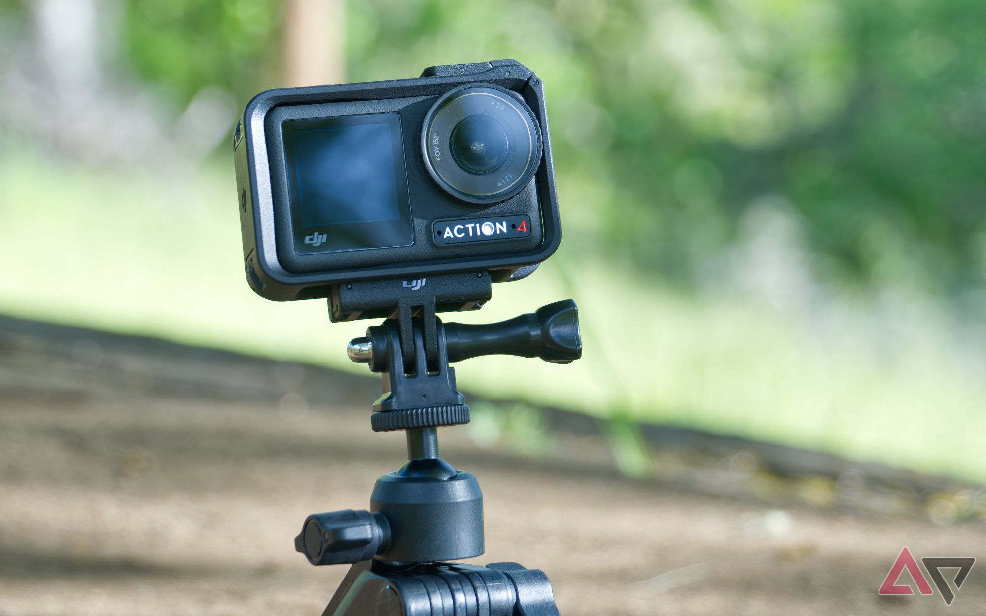 DJI Osmo Action 4 in shock-resistant case and attached to magnetic mount and tripod with forest in the background