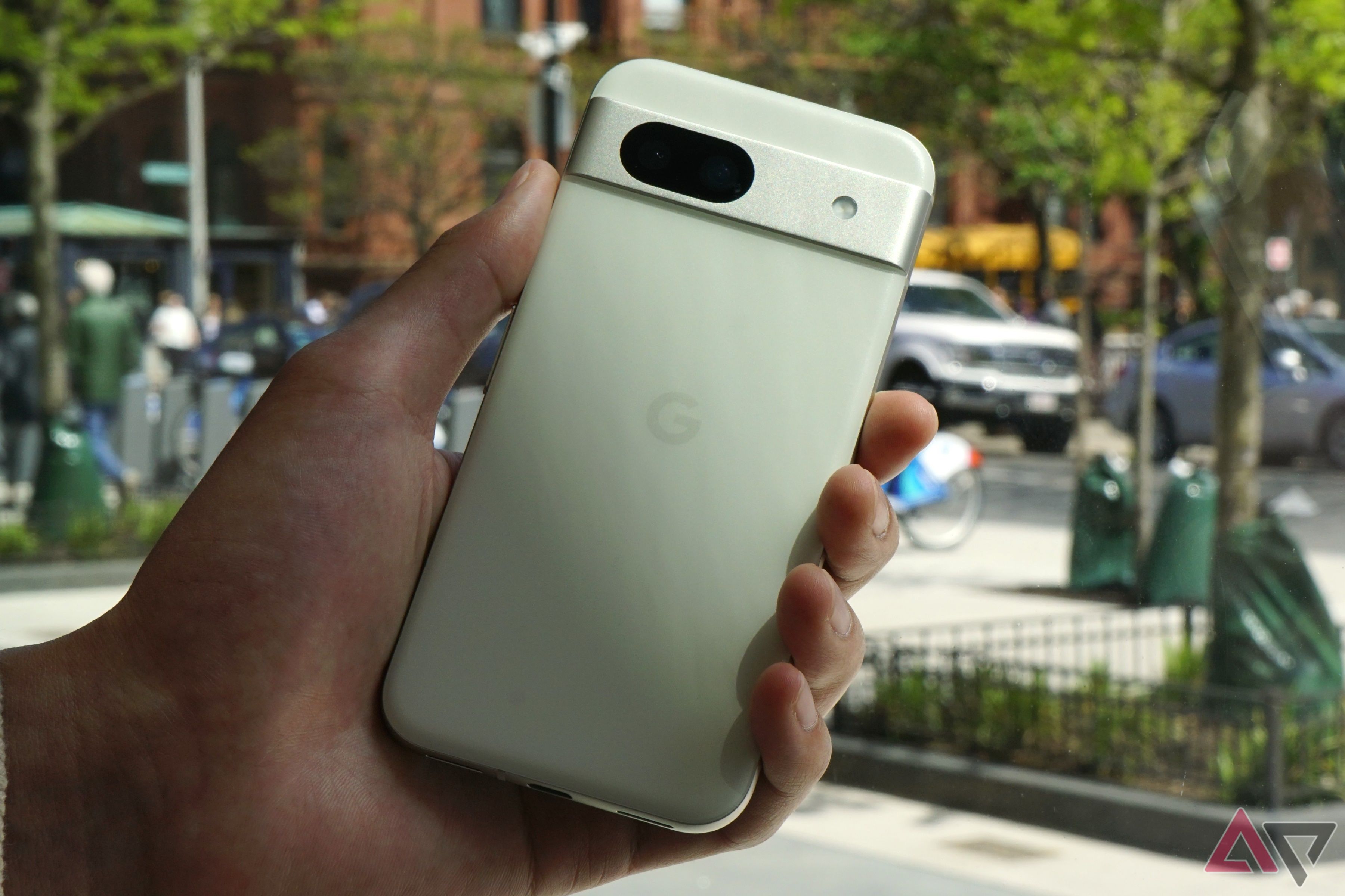 A white Pixel 8a held in someone's hand.