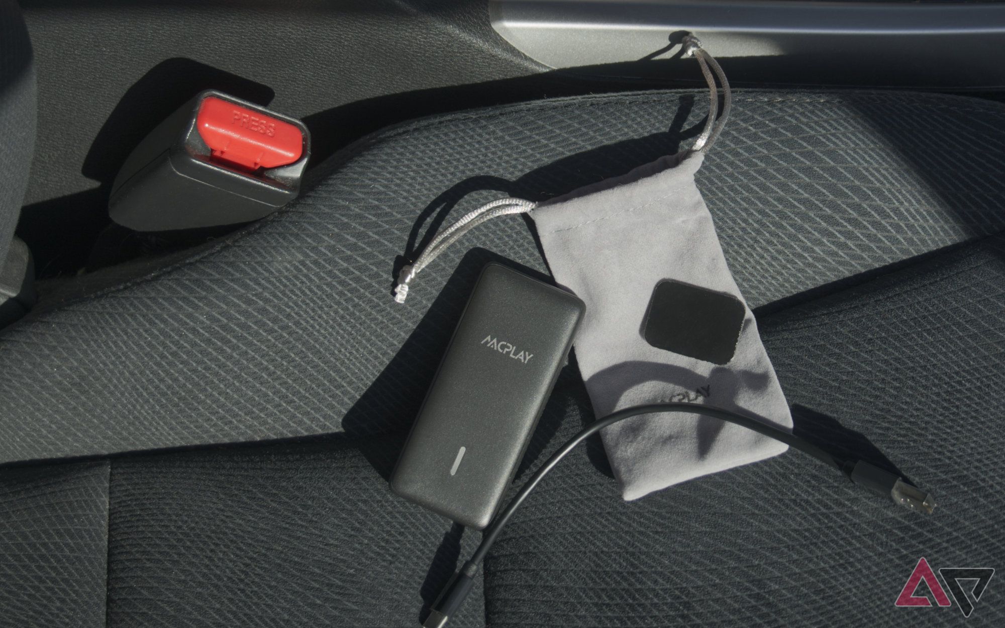 AACPlay adapter with accessories laying on a car seat