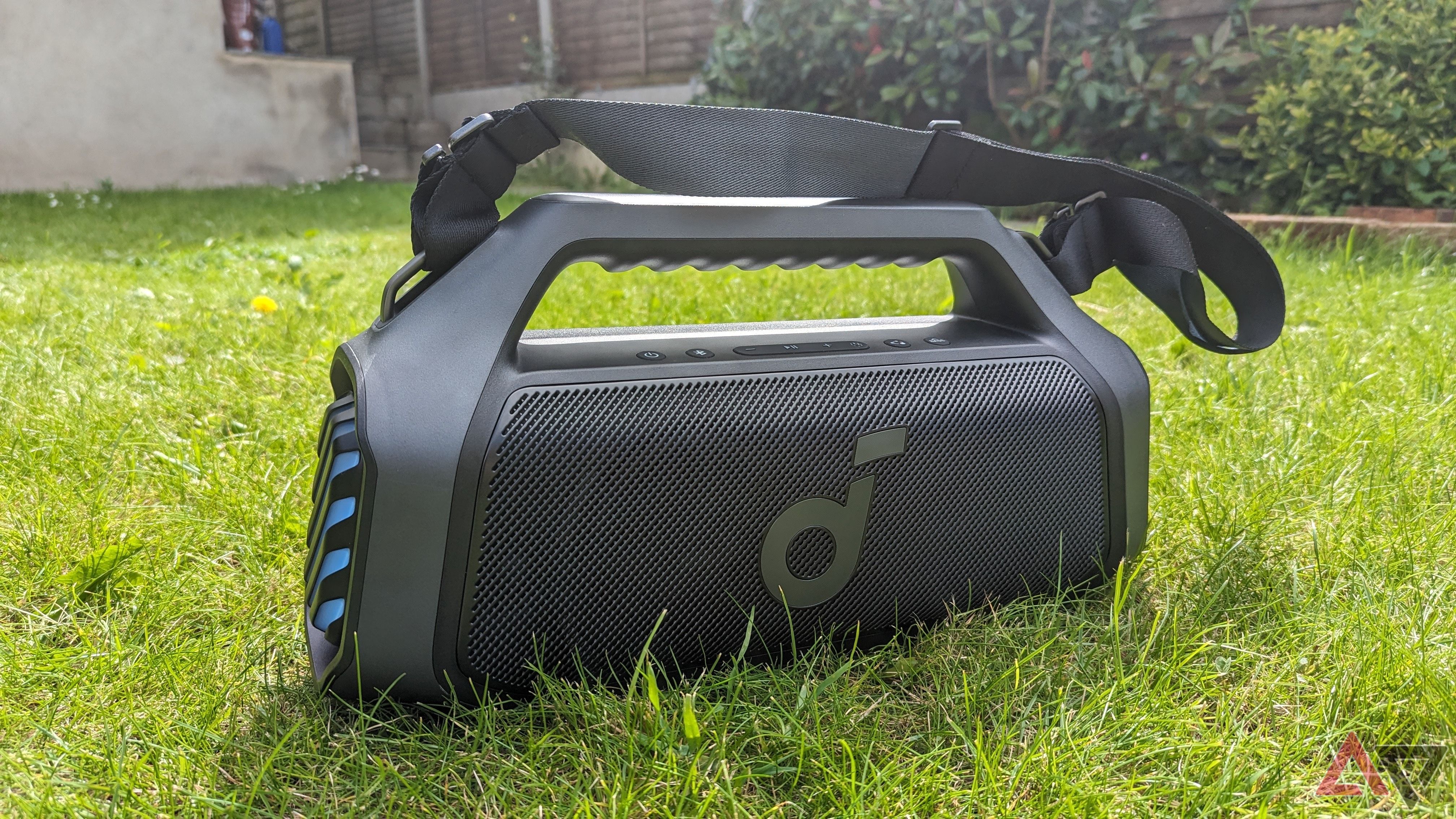 Anker Soundcore Boom 2 Plus turned on with detachable strap attached and placed on grass