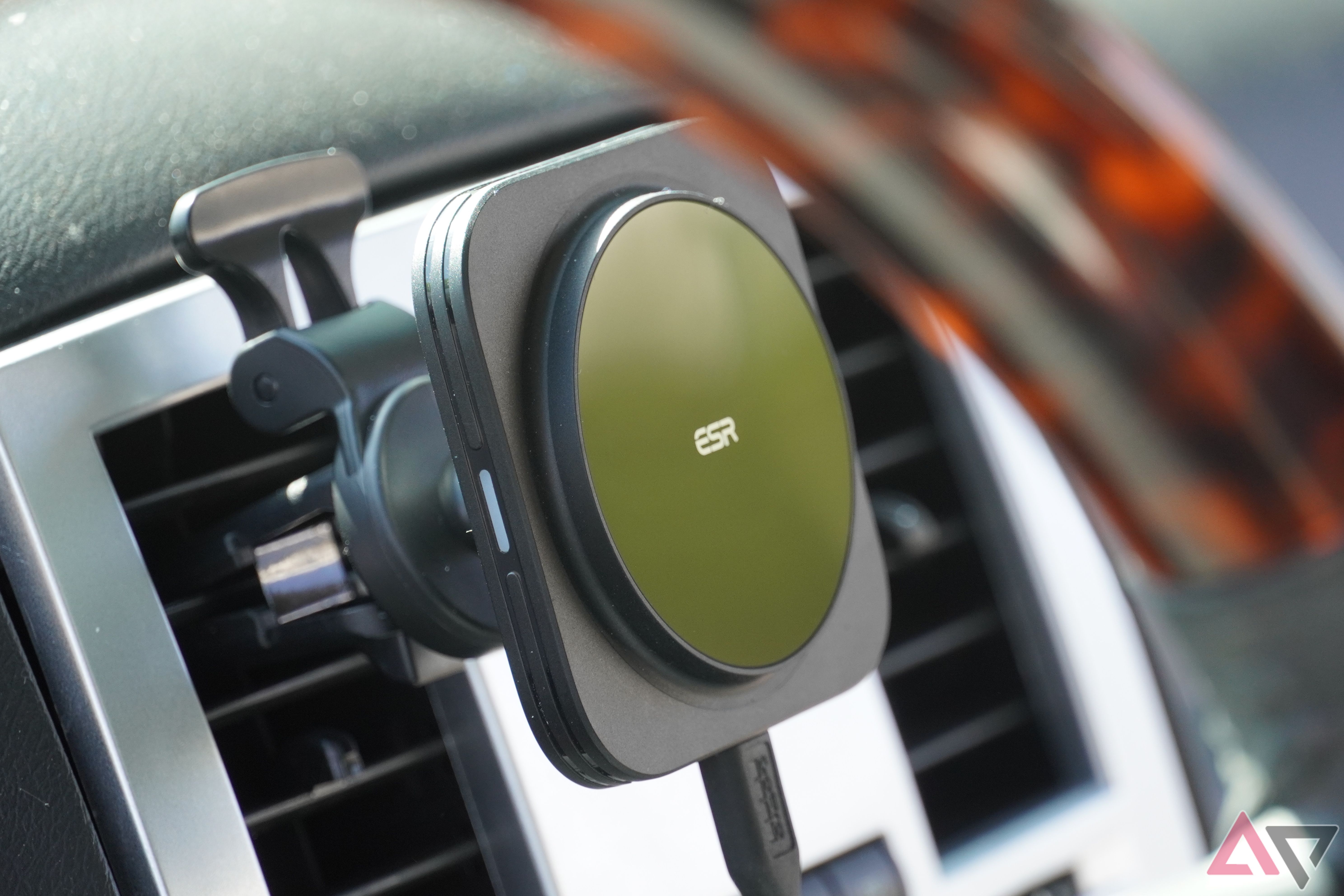 The ESR Qi2 Wireless Car Charger through the steering wheel of a car.