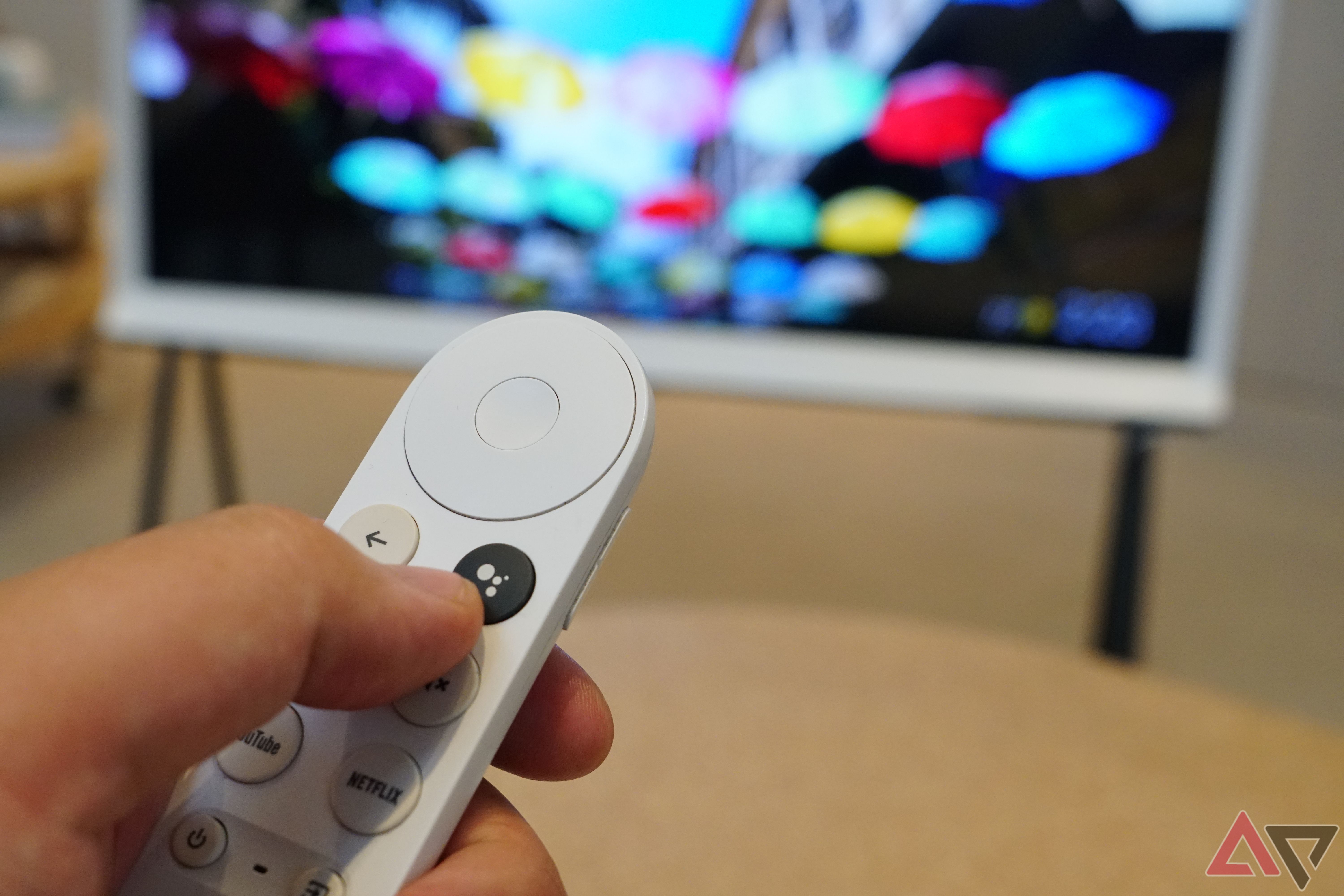 A Google TV remote with the Google Assistant button in view.