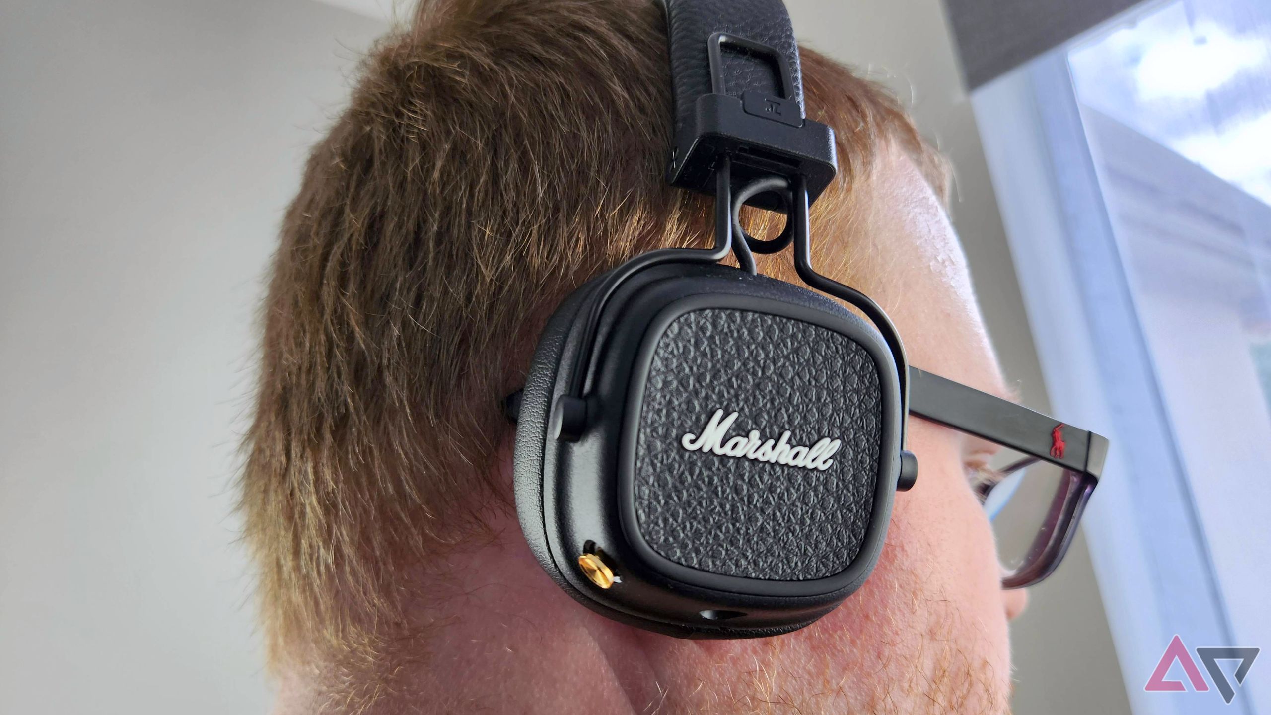 Listening to the Marshall Major V wireless headphones with a window in the background