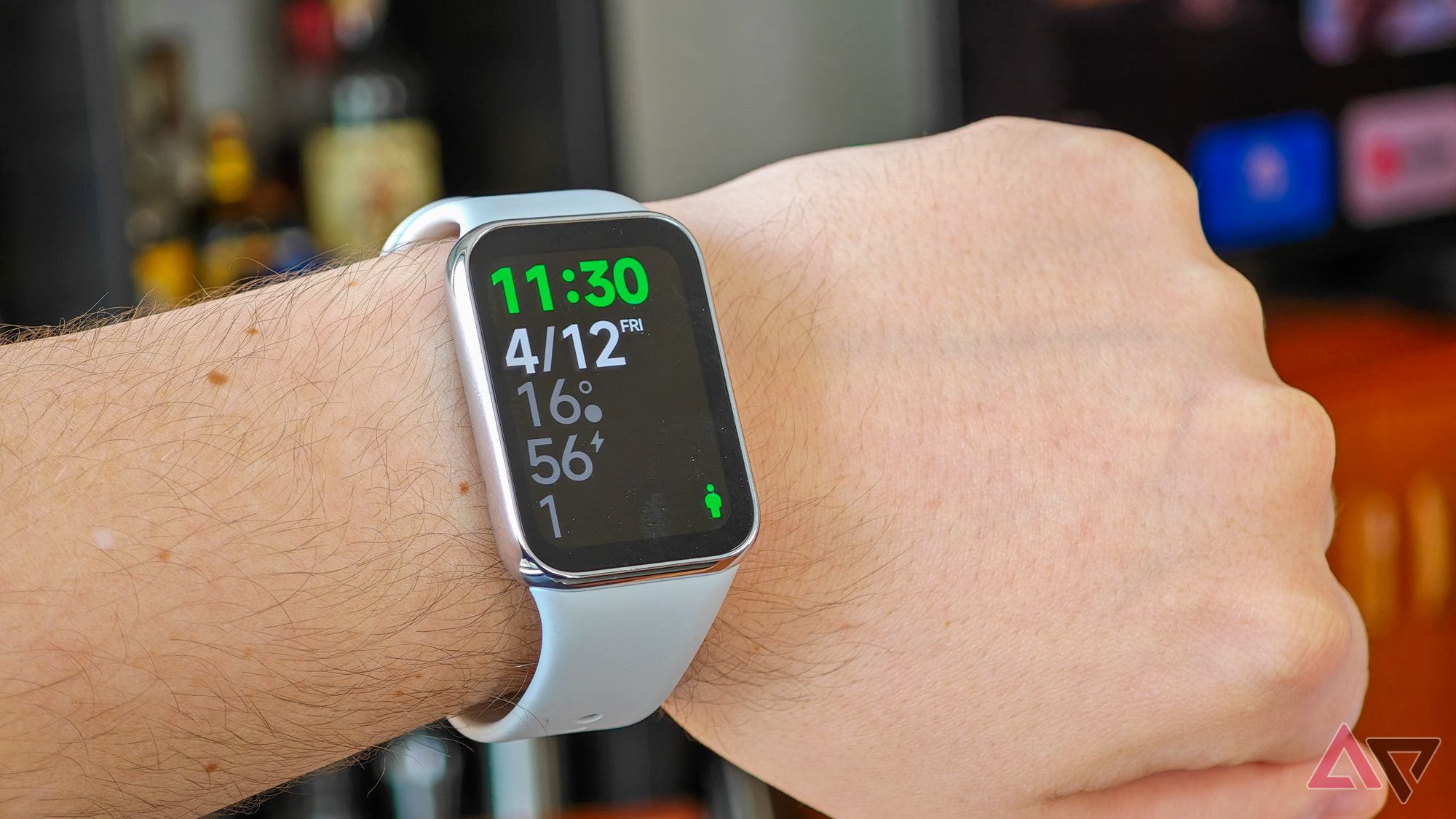 The Xiaomi Smart Band 8 Pro with a grey strap on a Caucasian man's wrist showing the home screen