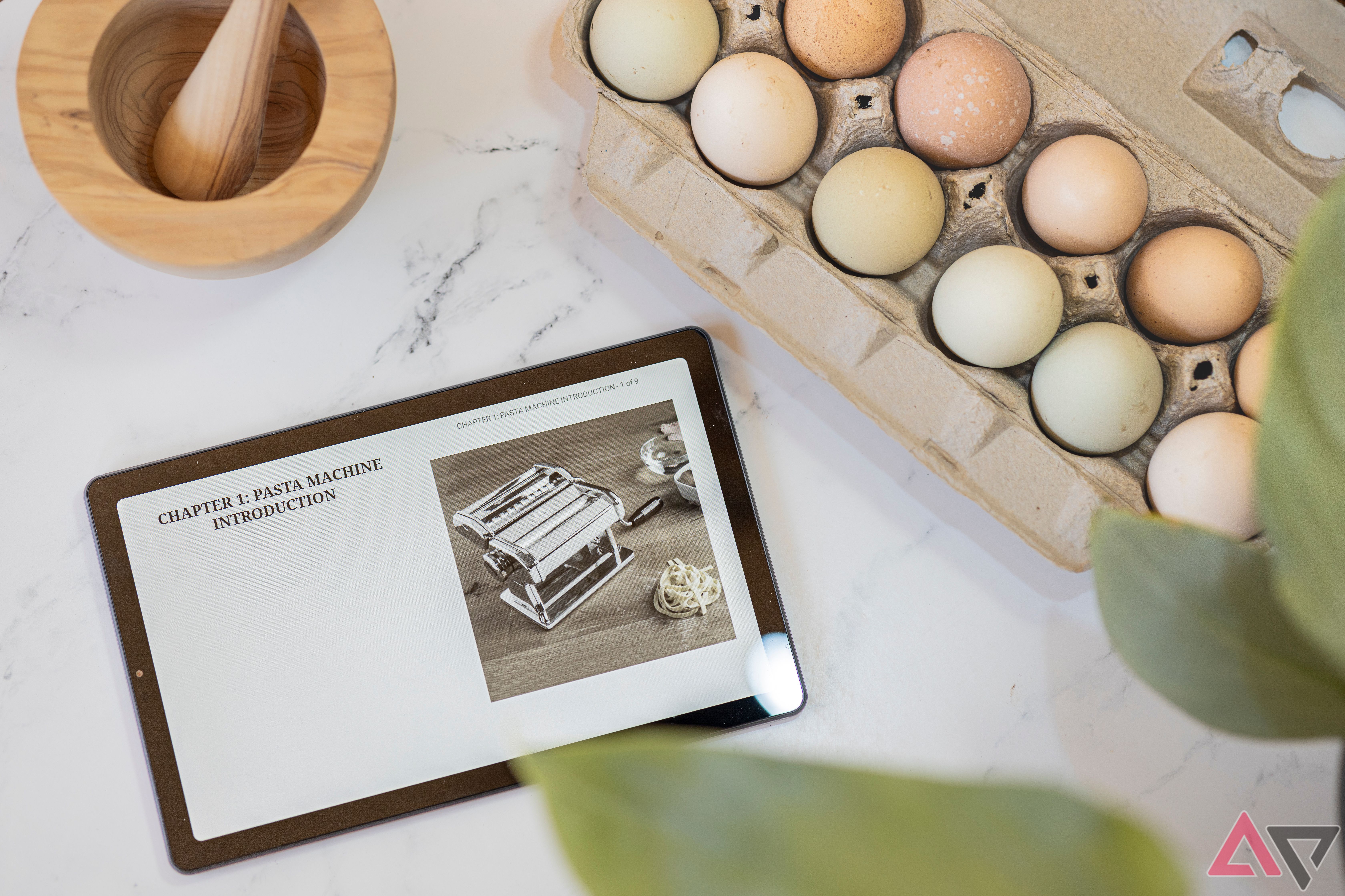 Nook 9" Lenovo Tablet open to pasta cookbook next to eggs and mortar and pestle