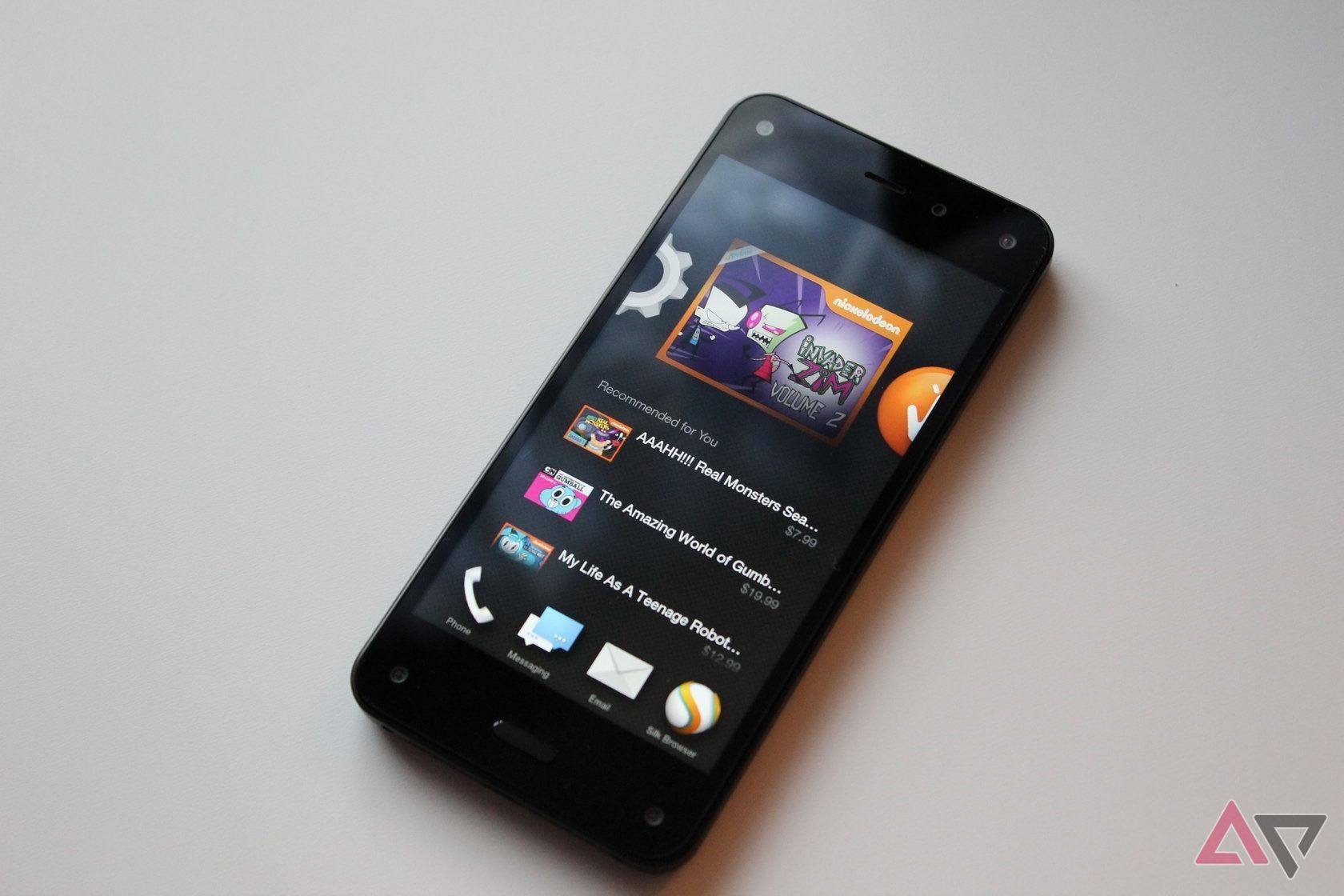 The Fire Phone sitting on a table with its home screen shown.