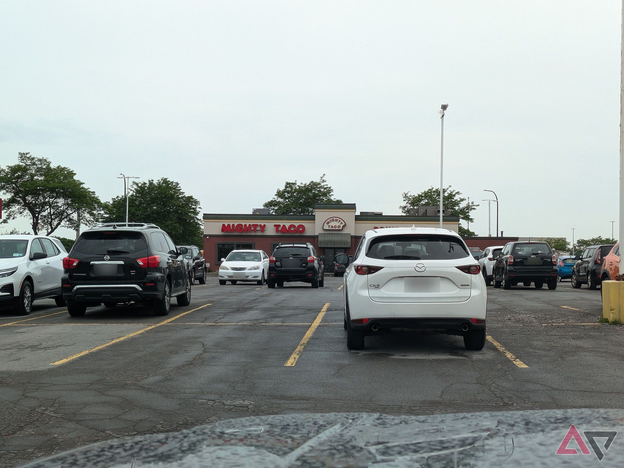 A photo taken from a parking lot of a fast food restaurant in the distance.