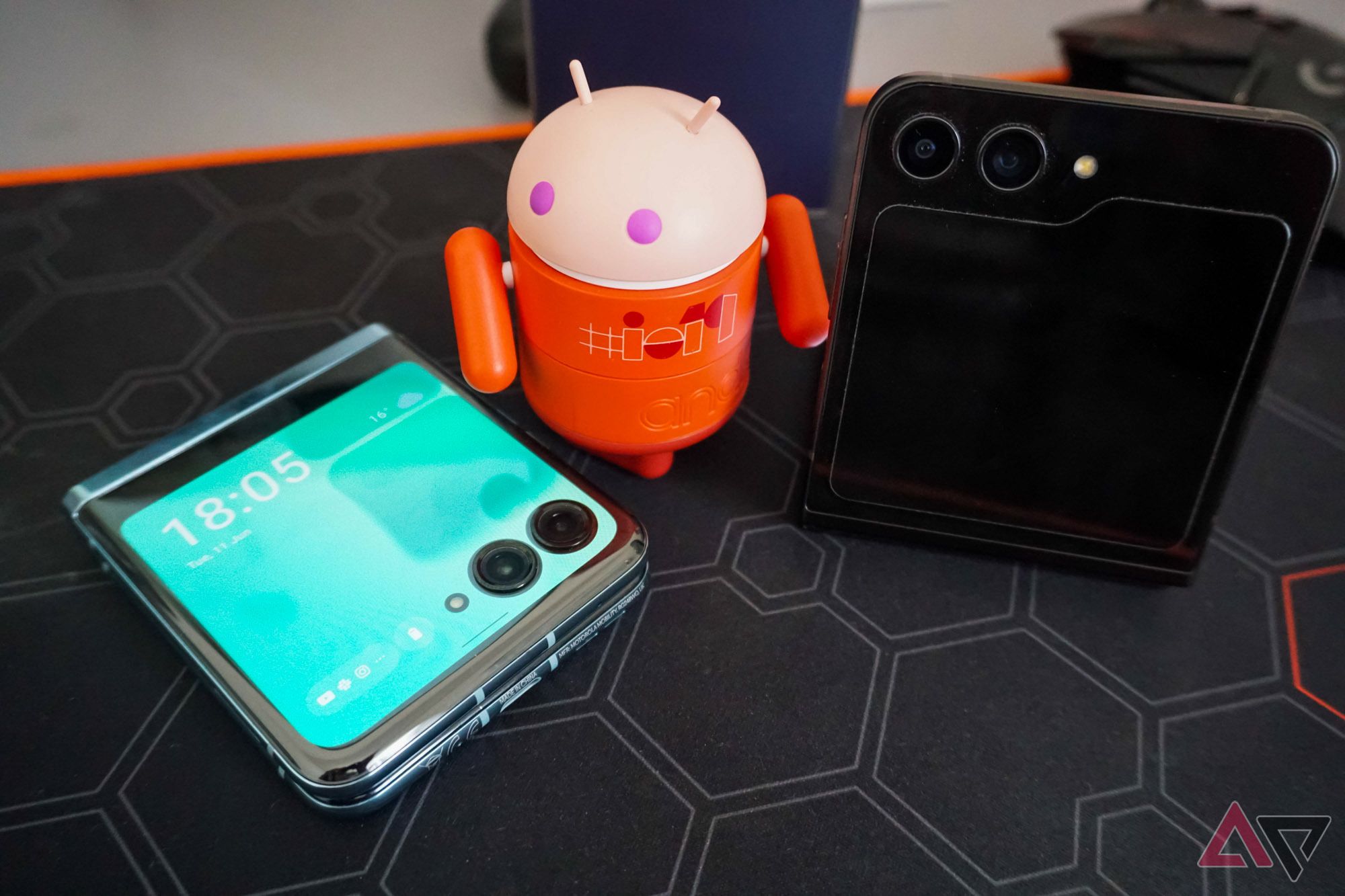 A photo of a little Android looking at a Moto Razr+