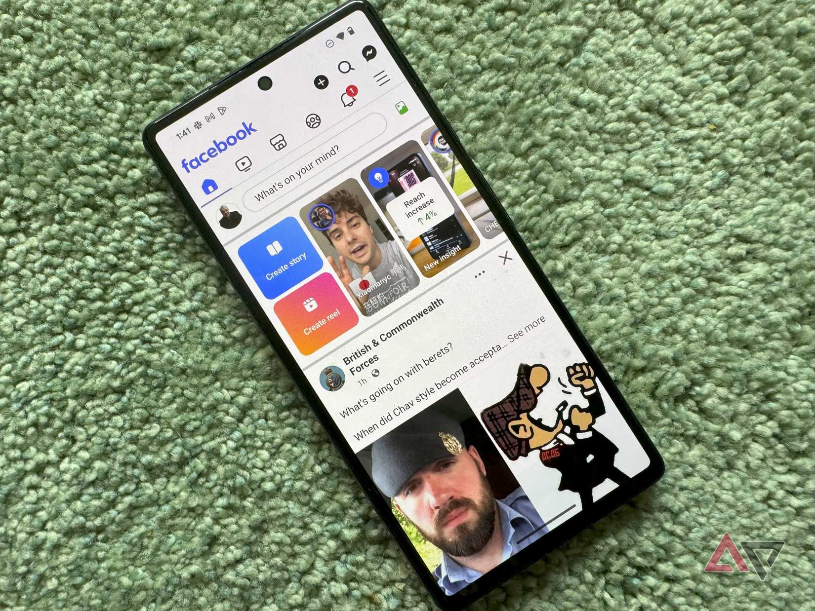 A Pixel phone on a green carpet with the Facebook app open on it.