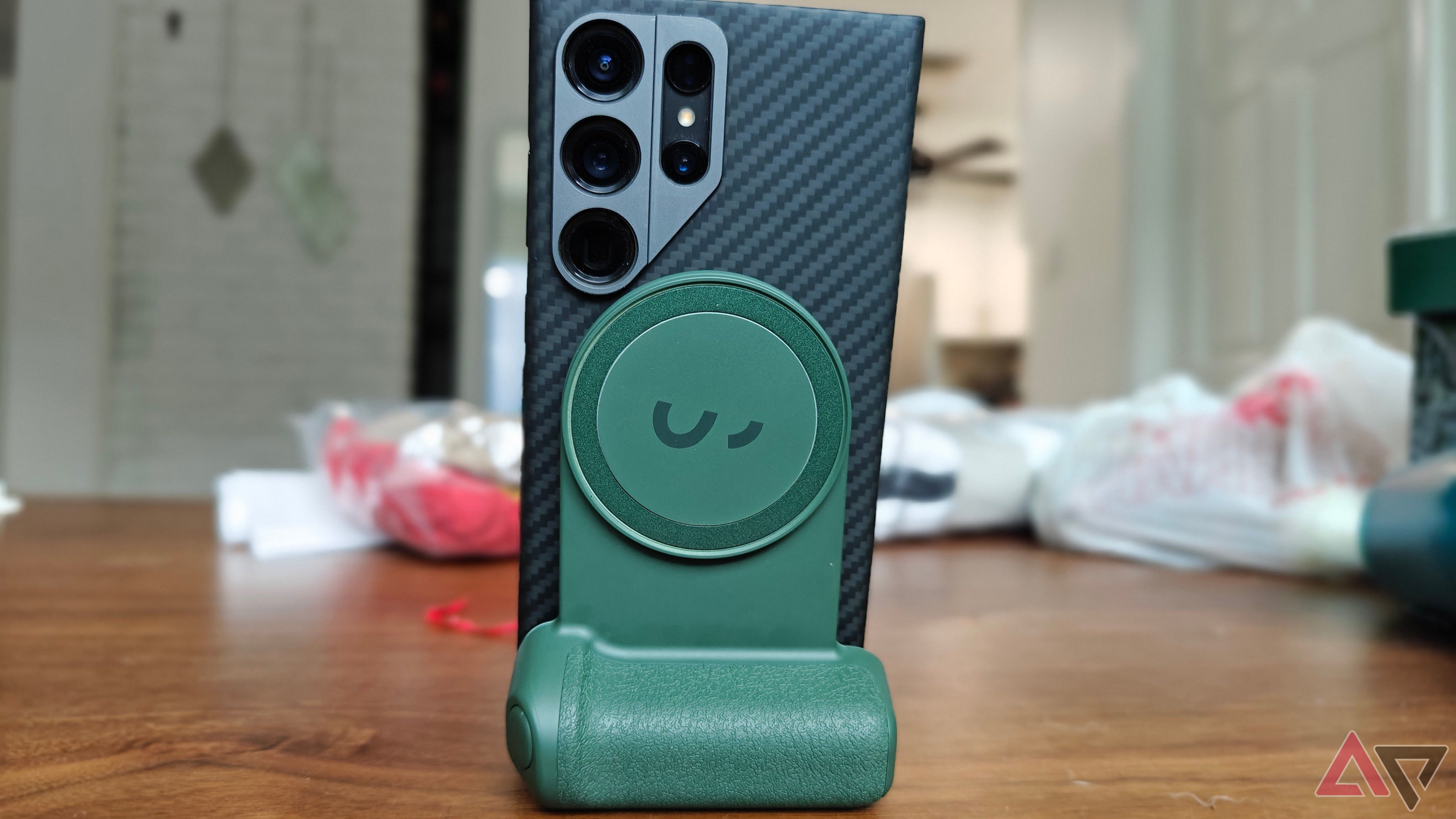 A green ShiftCam SnapGrip holding a black smartphone in desktop mode