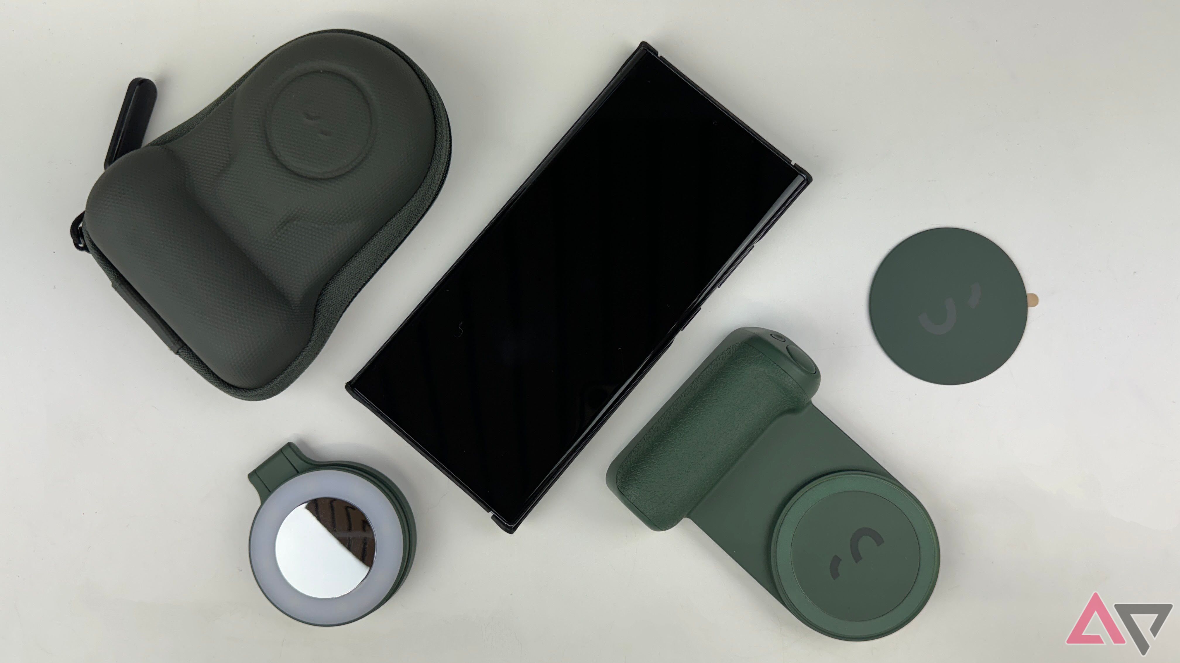 The SnapGrip, magnetic ring light, MagSafe sticker, and pouch around a black smartphone