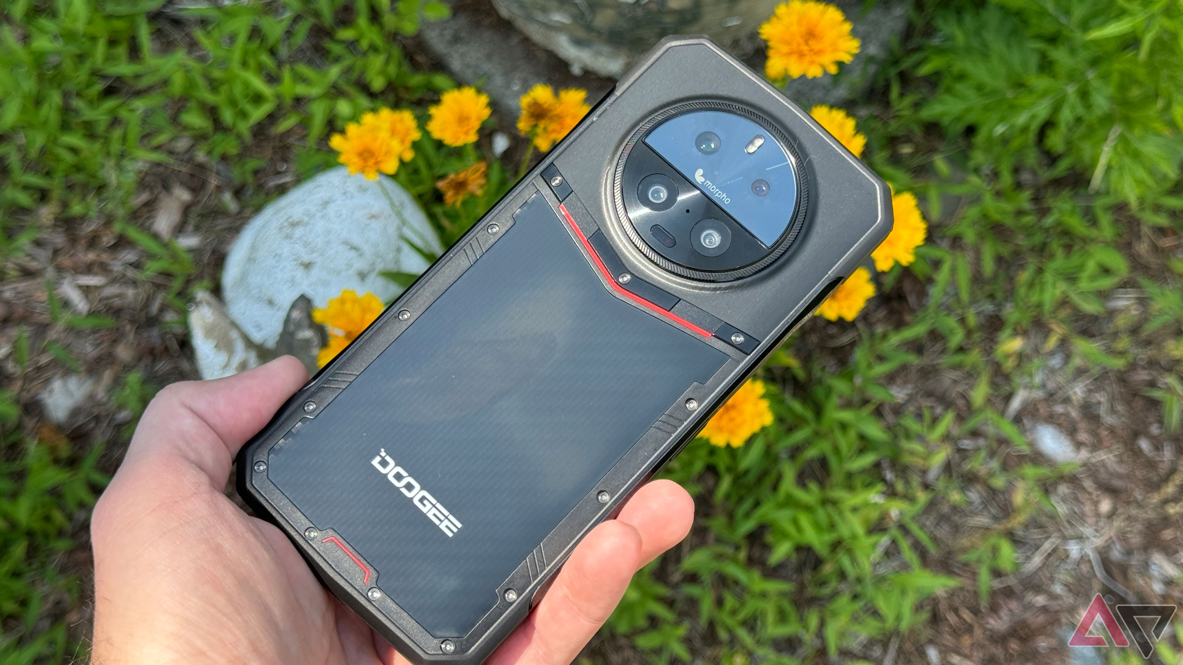 Doogee DK10 held above some yellow flowers