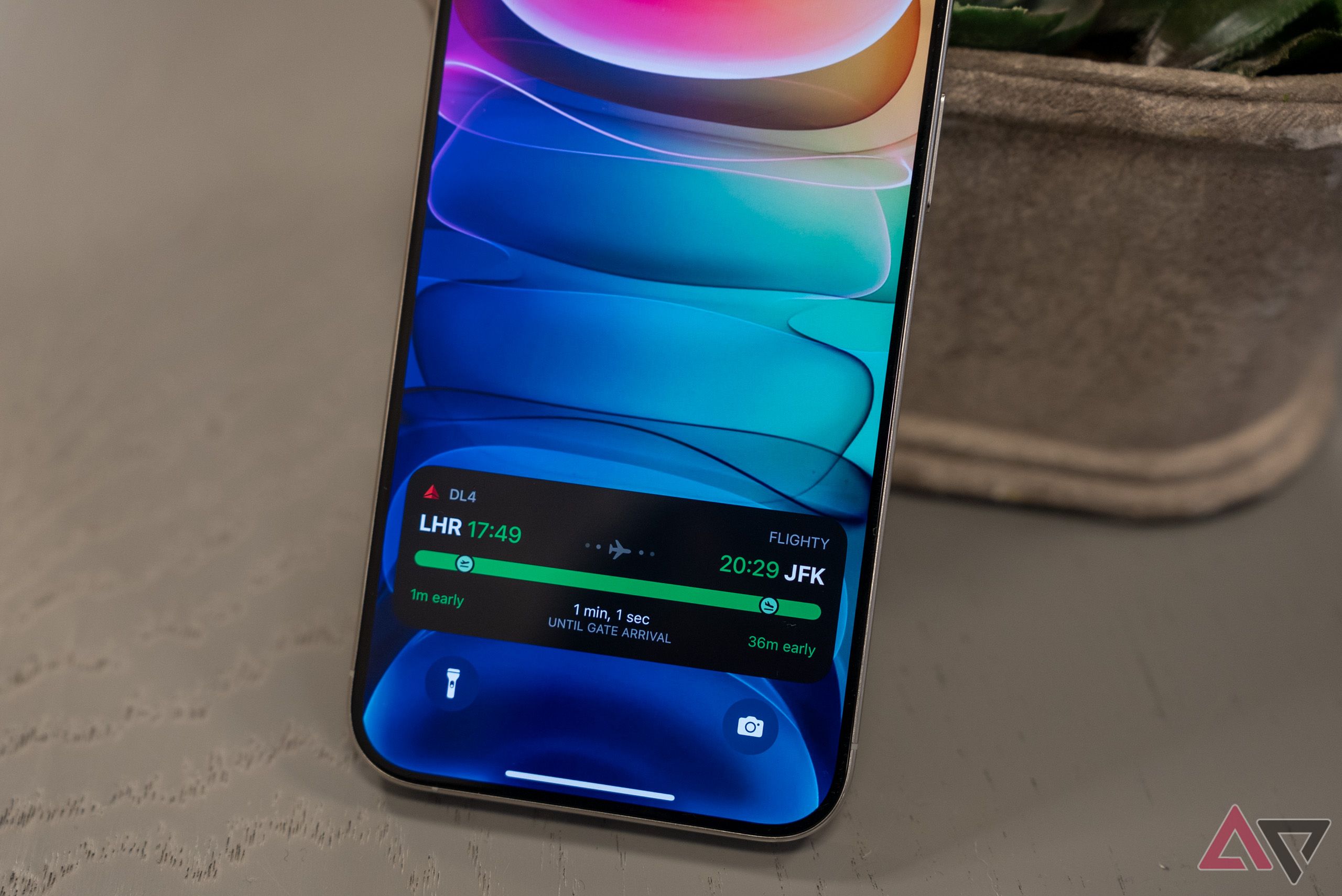 An iPhone showing a Live Activity on the lock screen tracking a flight.