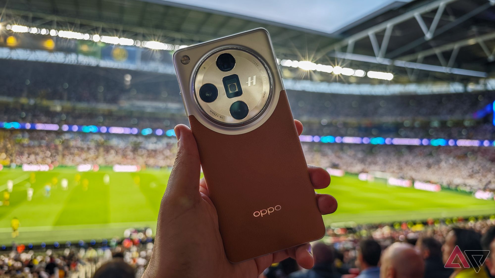 The Oppo Find X7 Ultra in front of a football pitch.
