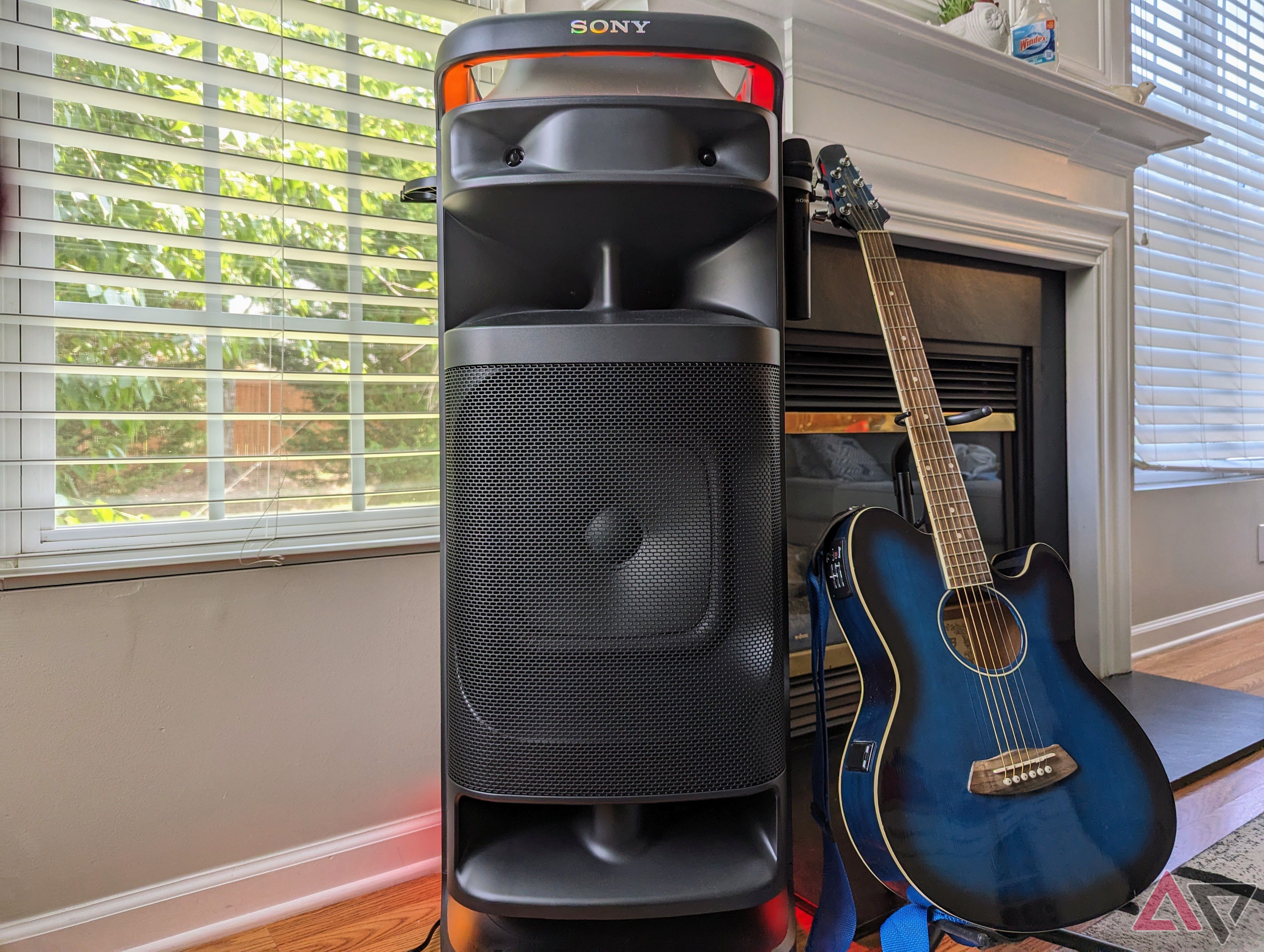 Sony Ult Power 10 tower speaker next to a blue acoustic guitar