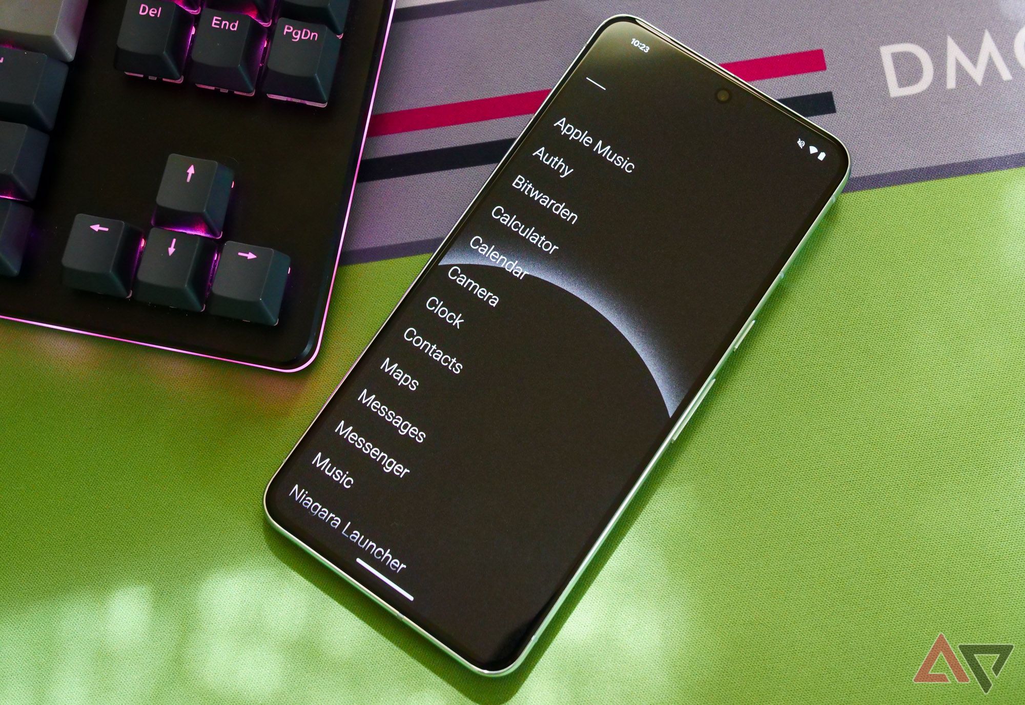 A Pixel 8 Pro lying next to a keyboard with a list of apps on screen.