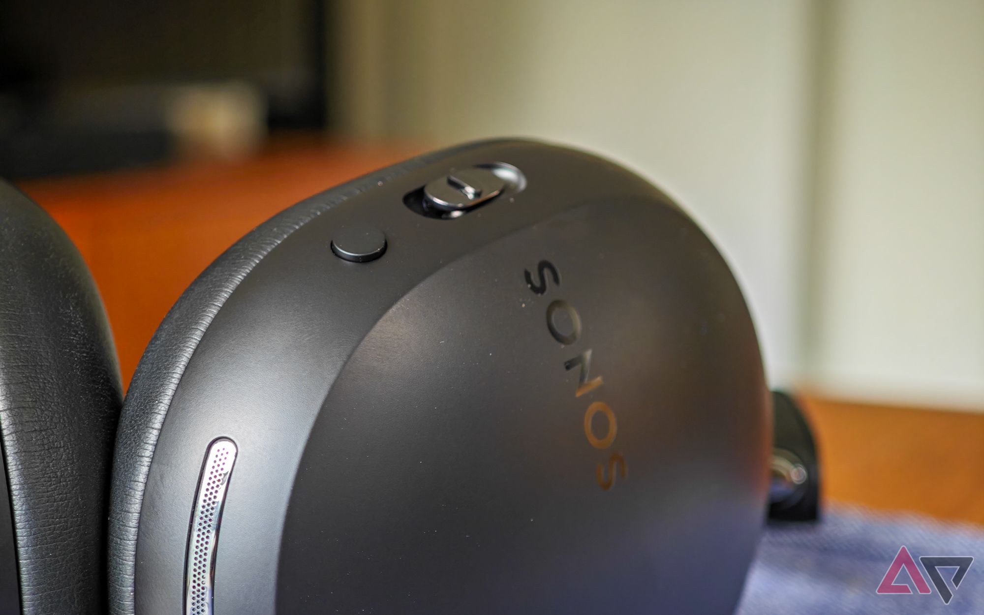 Sonos Ace headphones in black lying on a table, with the Play button visible