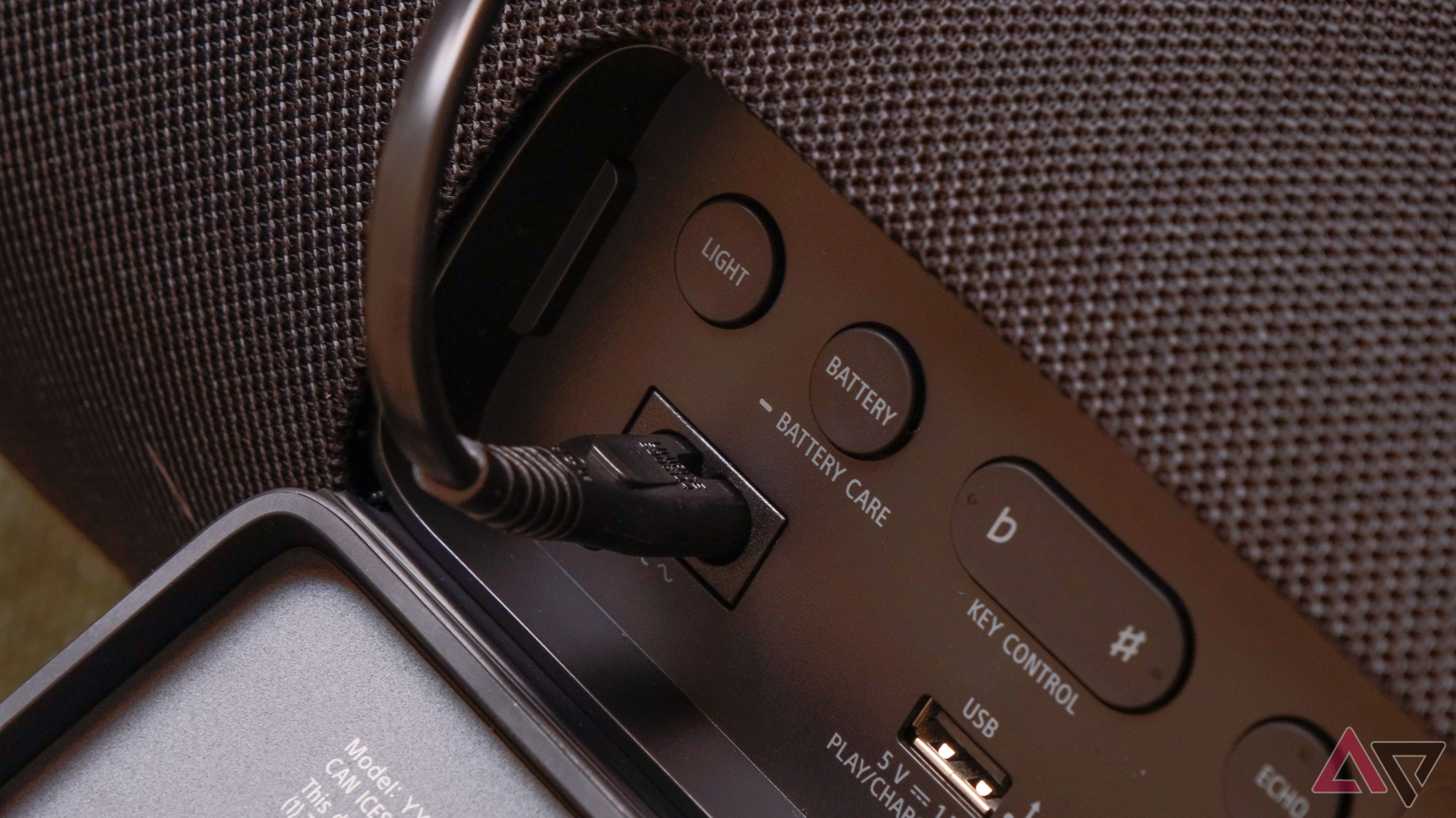 A charging cable connected to a Sony speaker.