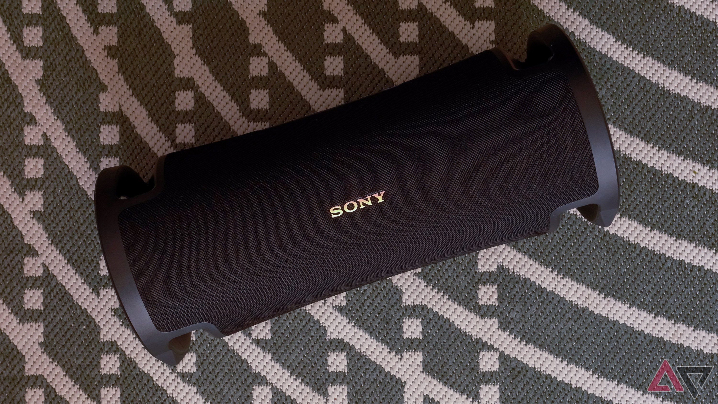 A Sony speaker on a green rug.