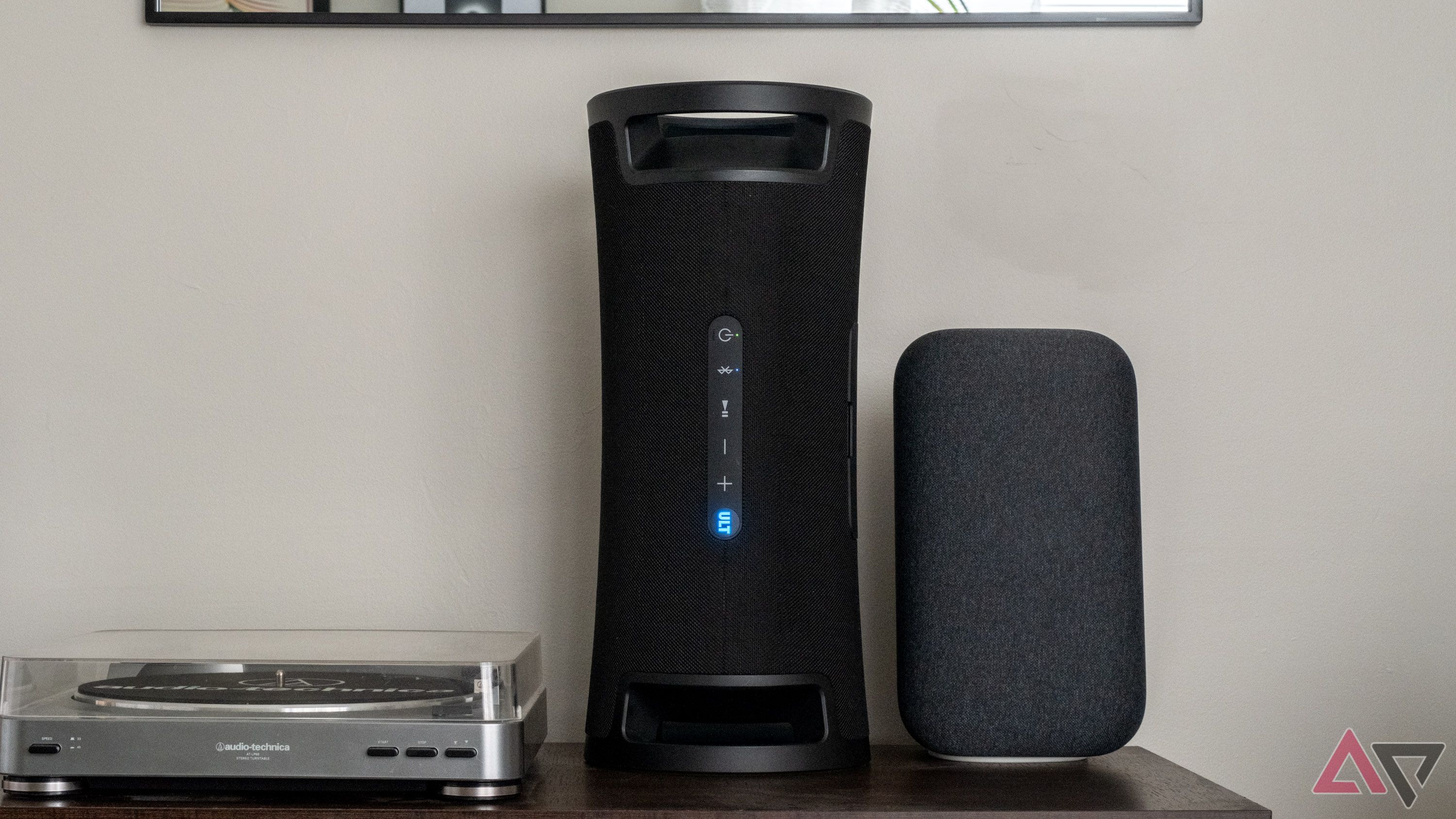 A Sony speaker between a turntable and a Google speaker