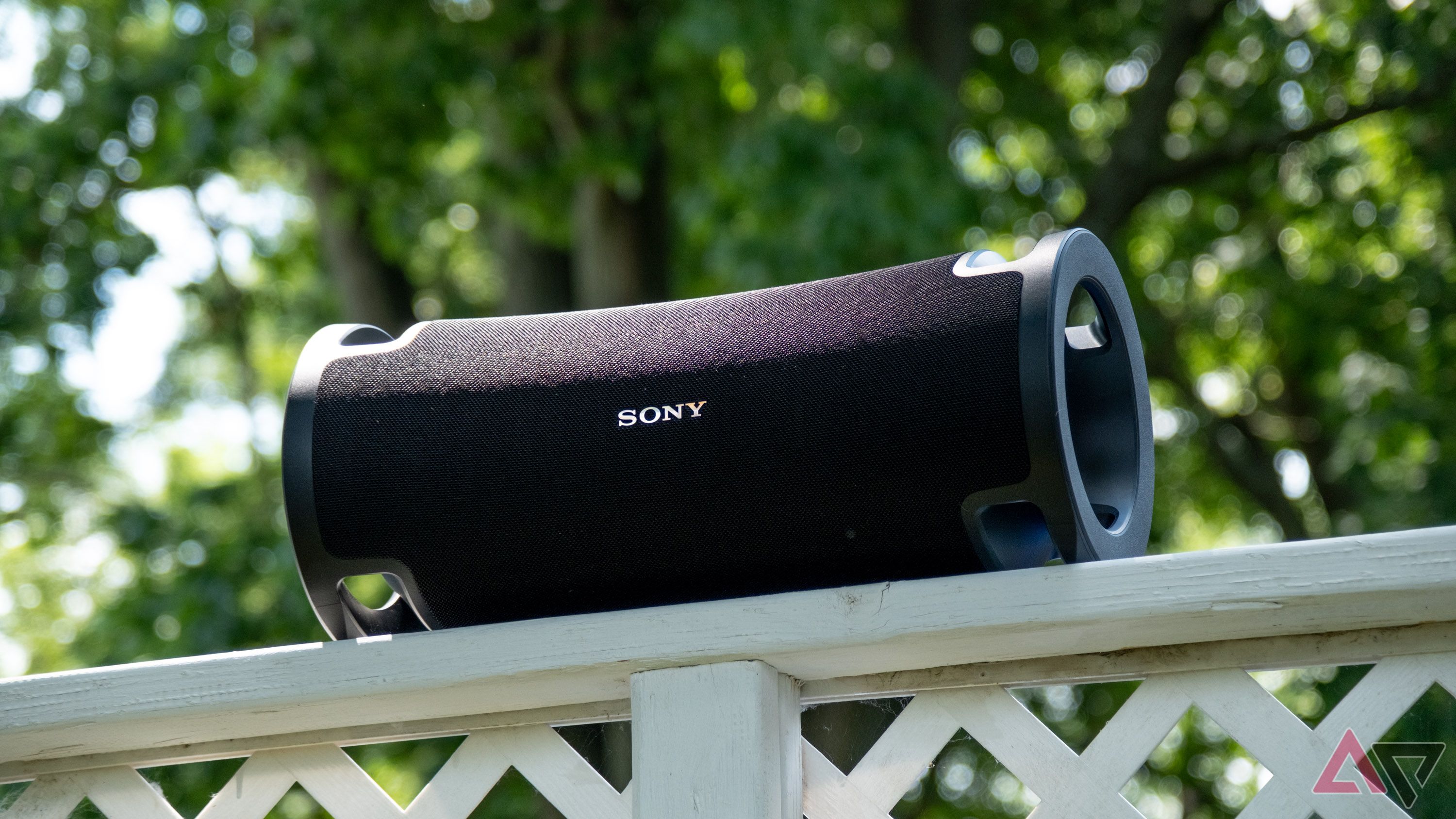 A large Bluetooth speaker on a fence