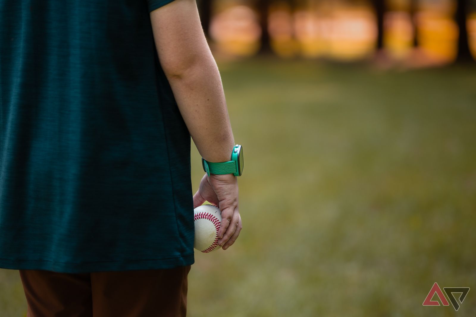 Child viewing sunset while holding baseball and wearing Garmin Bounce smartwatch