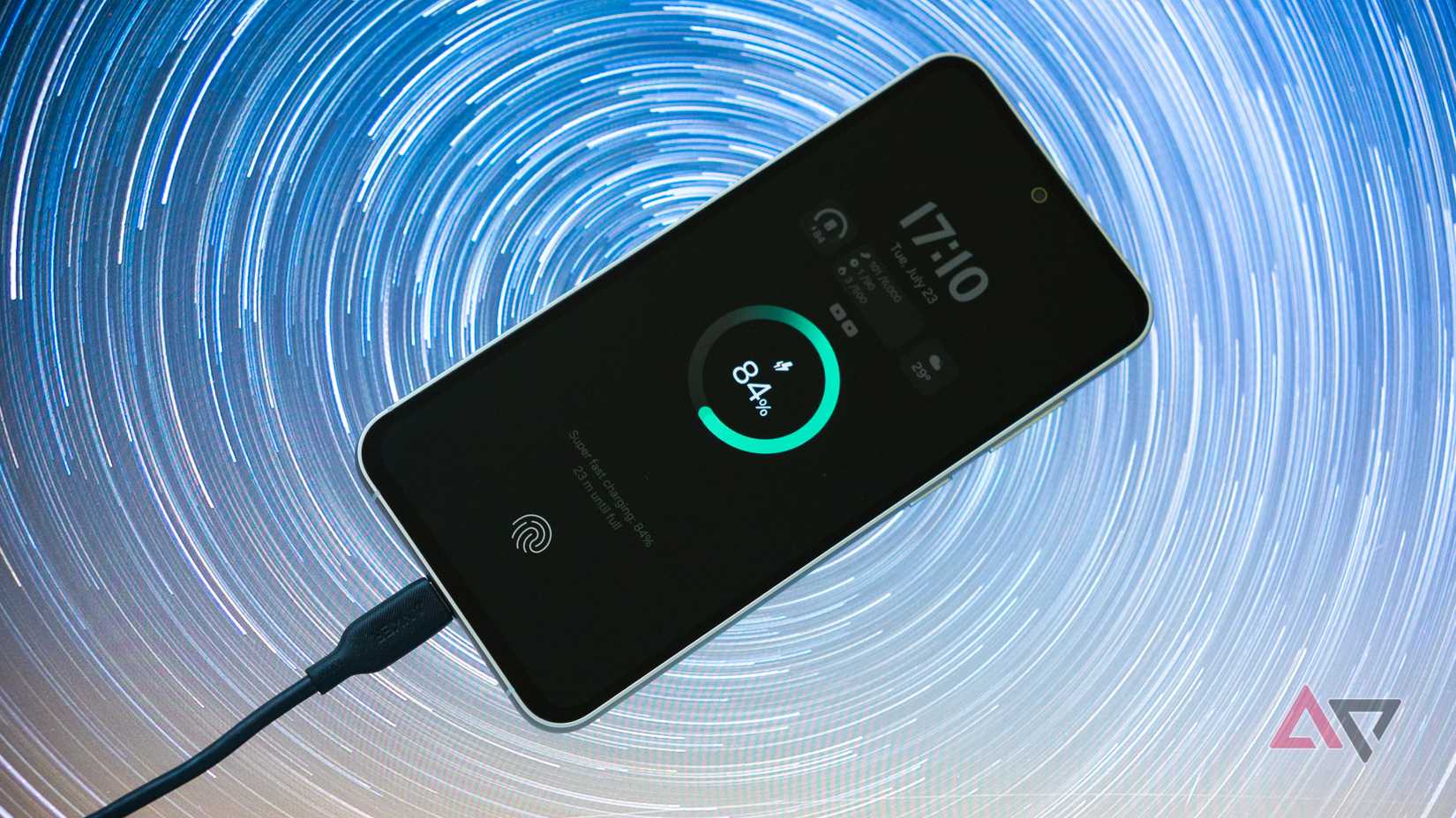 smartphone with charger plugged in showing 84% on a patterned background