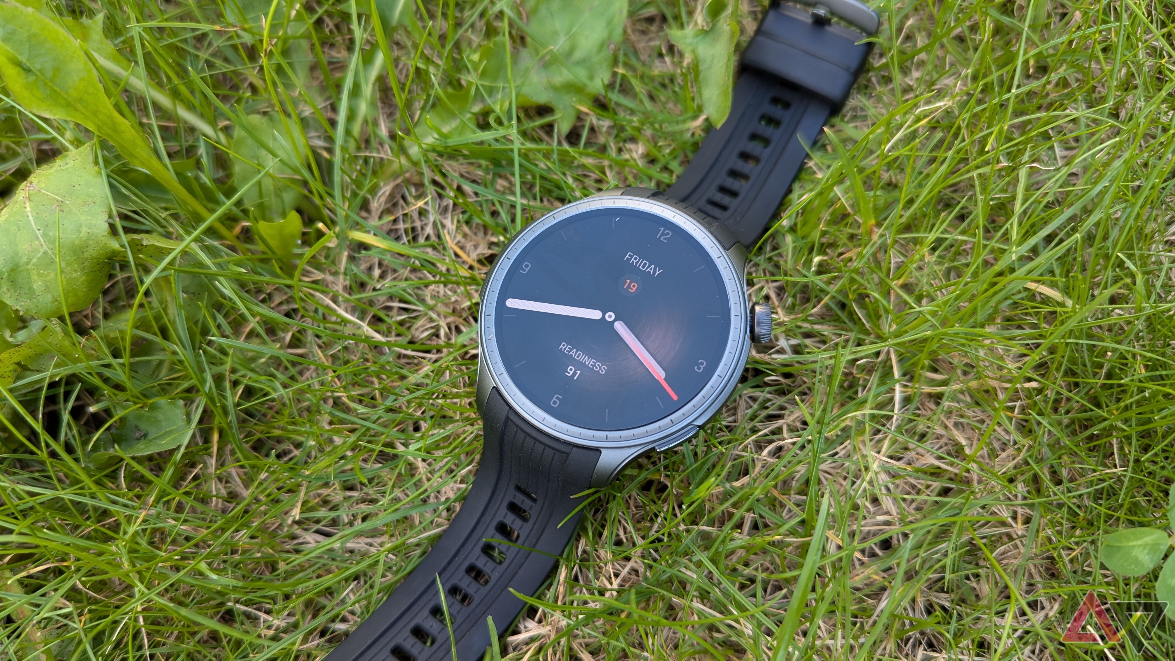 Amazfit Balance smartwatch in Midnight color outdoors laying on grass