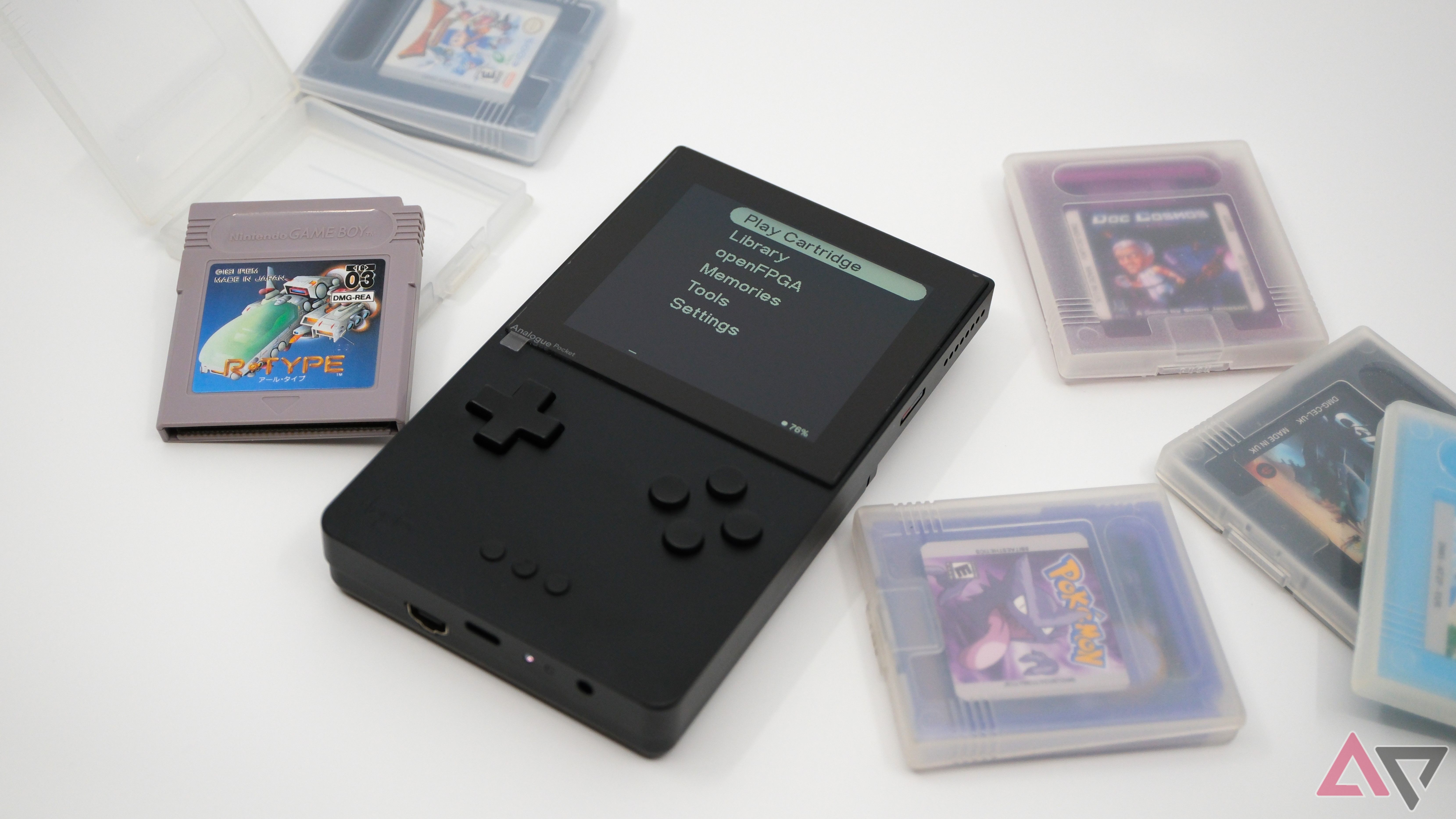 analogue pocket aluminum edition sitting on white background with games scattered around