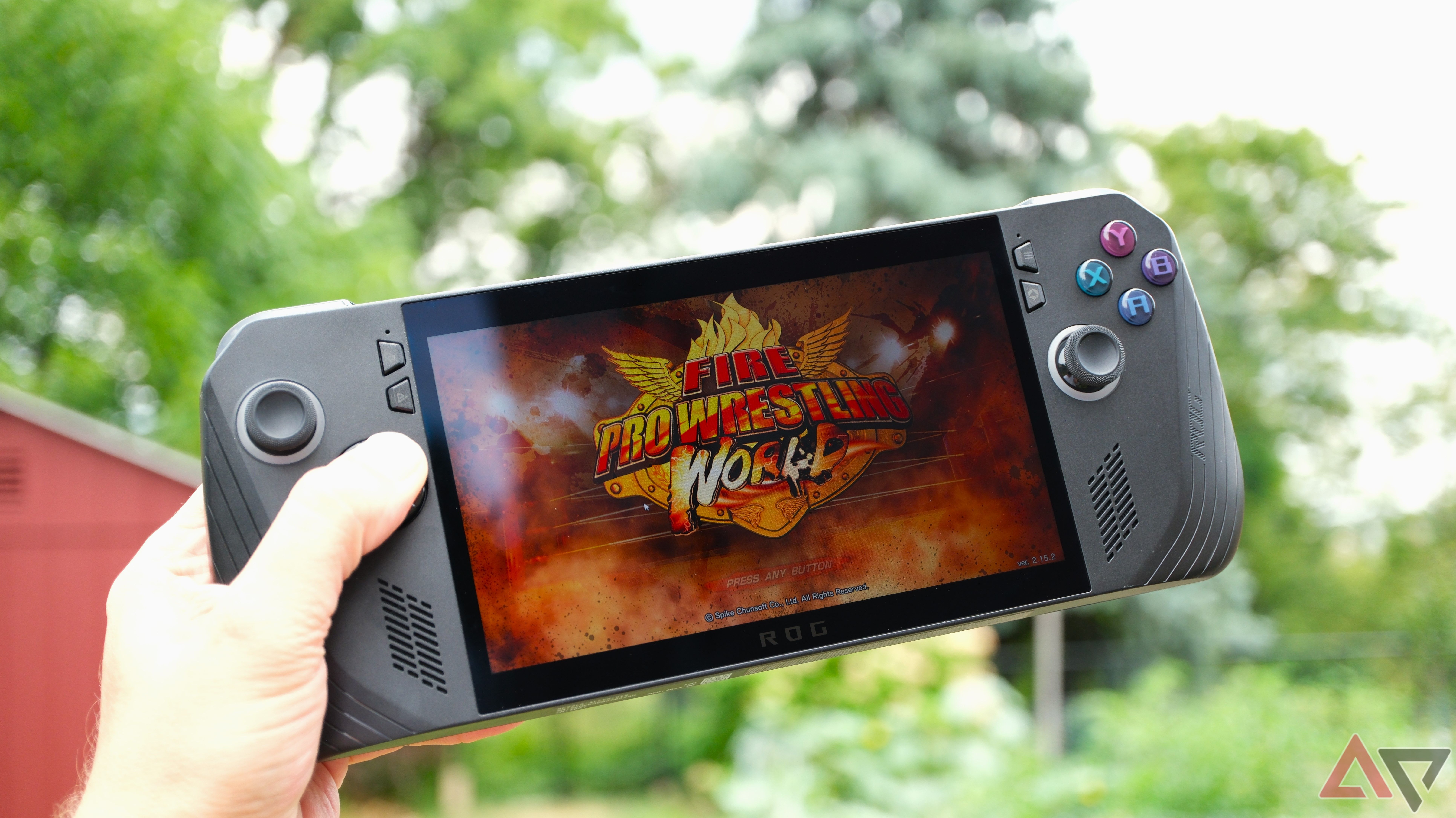 Asus ROG Ally X held in hand showing fire pro wrestling on the screen