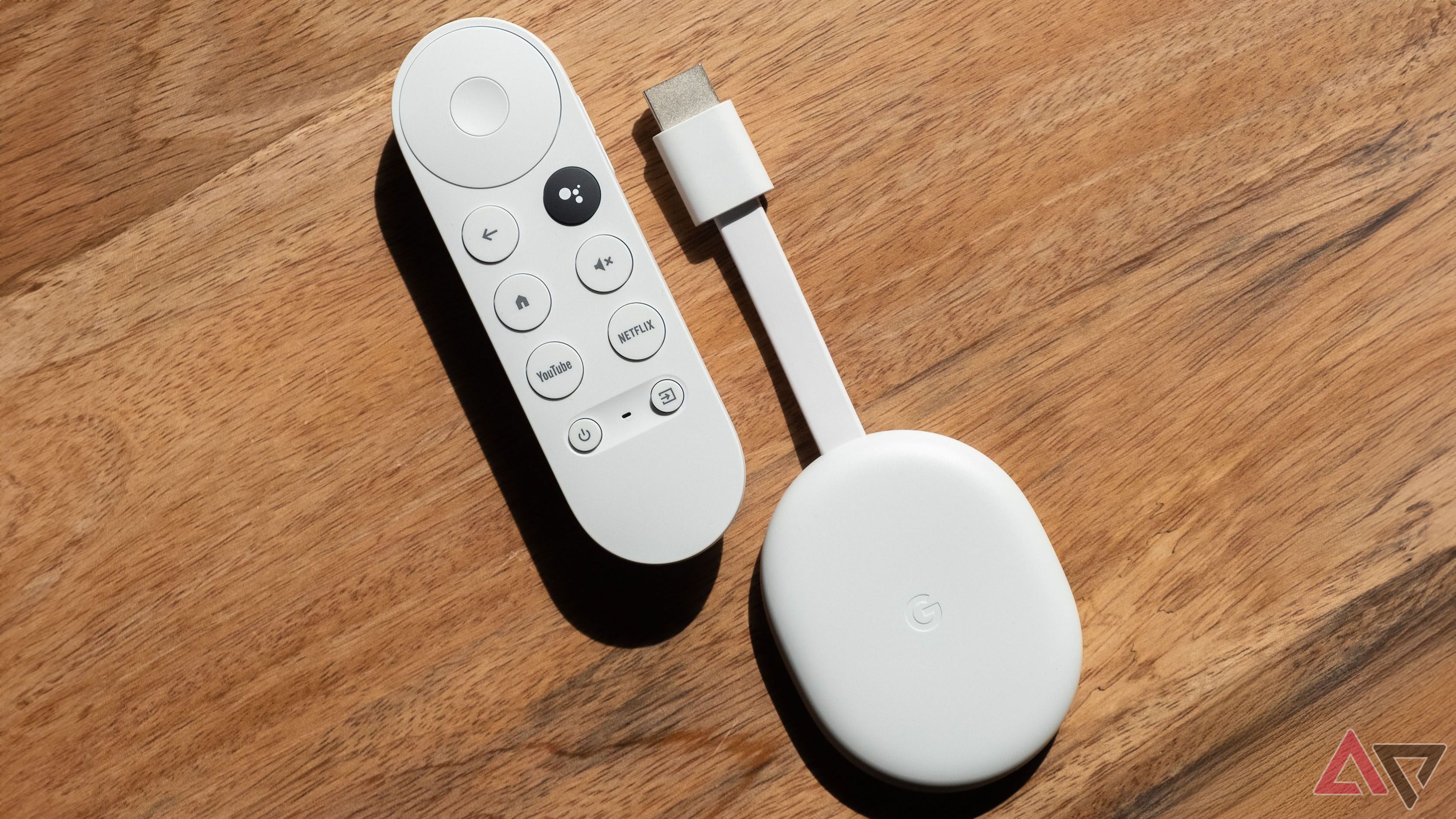 A Chromecast with Google TV sitting on wood.