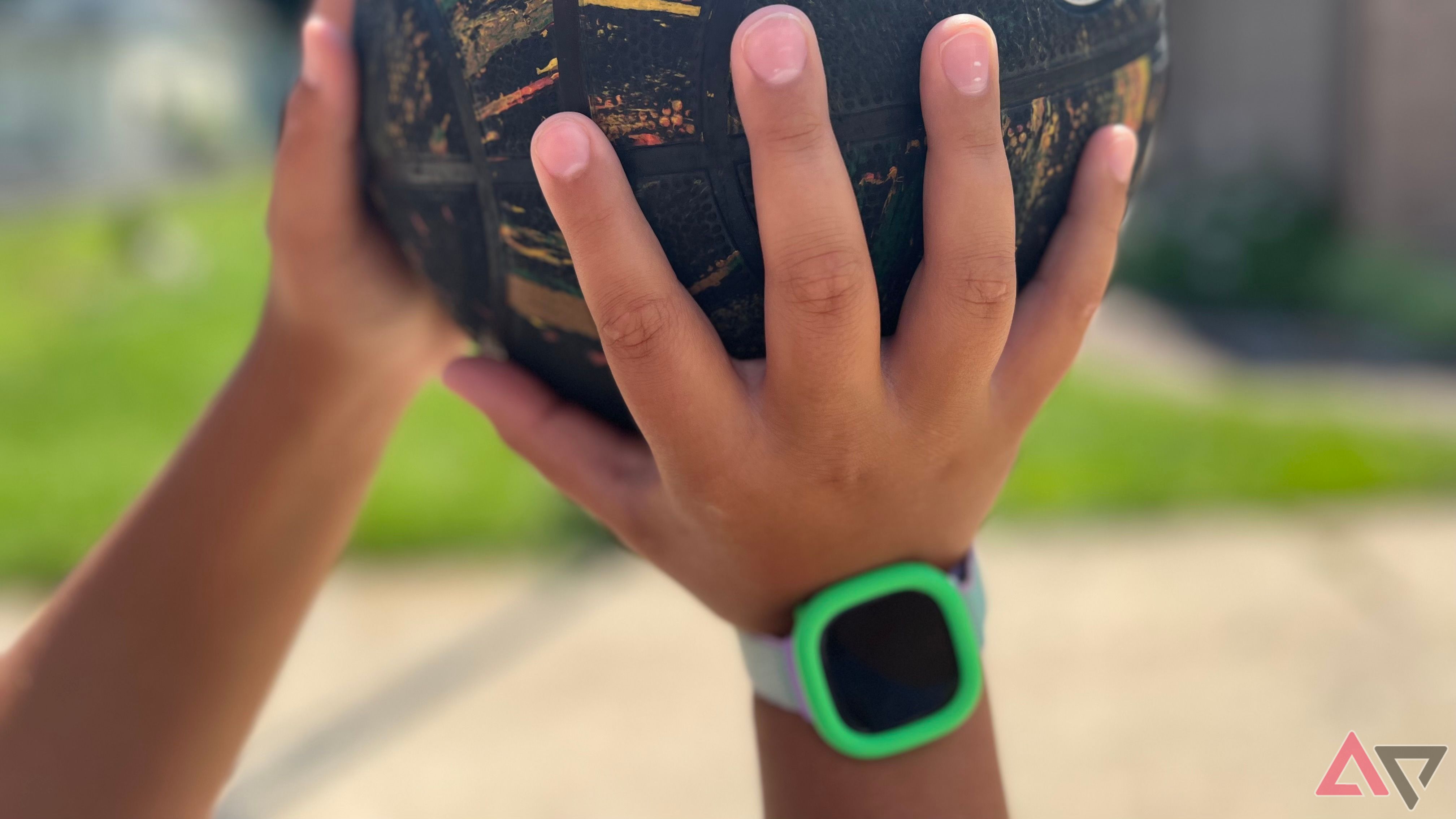 Person wearing Fitbit Ace LTE while holding ball