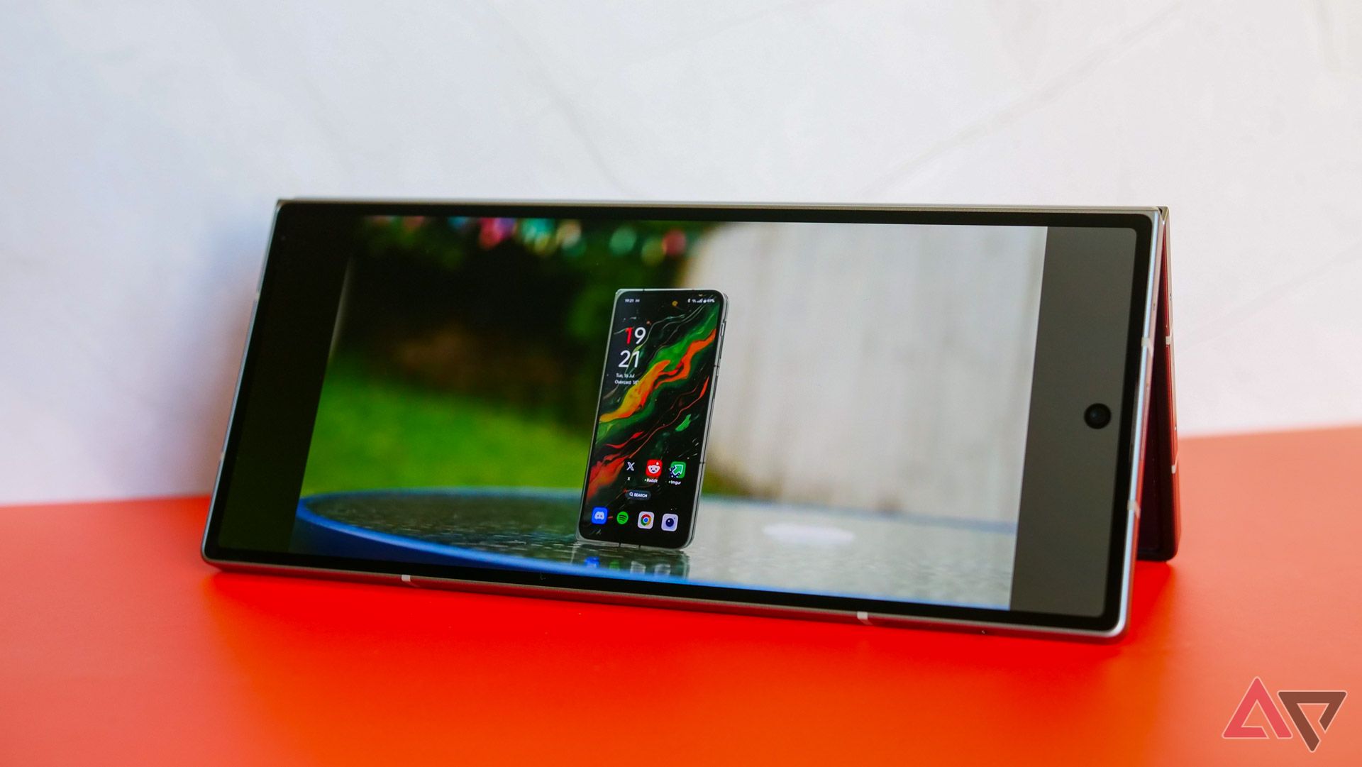 The Galaxy Z Fold 6 on an orange and white backdrop in tent mode, with a video playing.