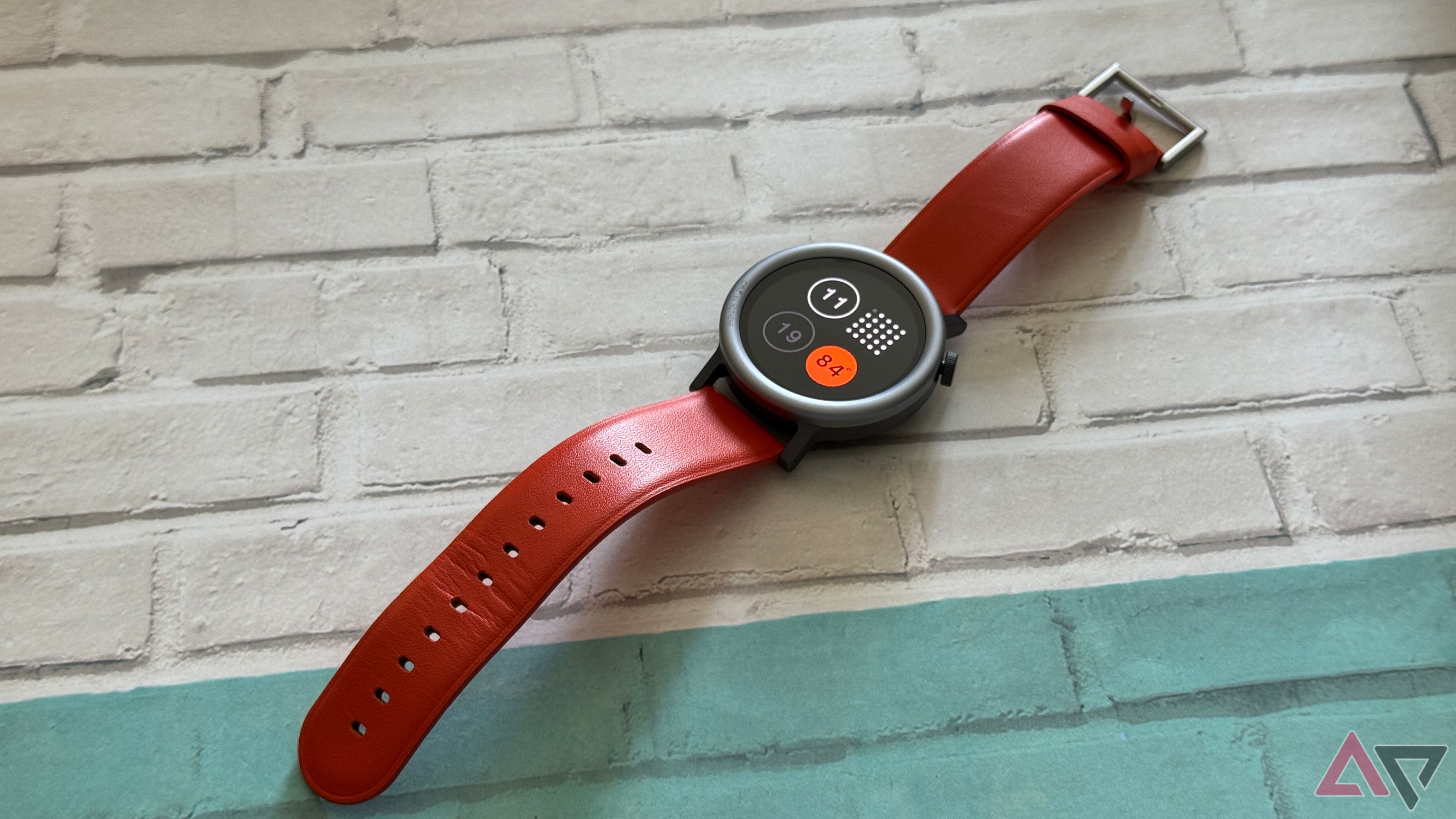 CMF Watch Pro 2 in orange laying on a table backdrop