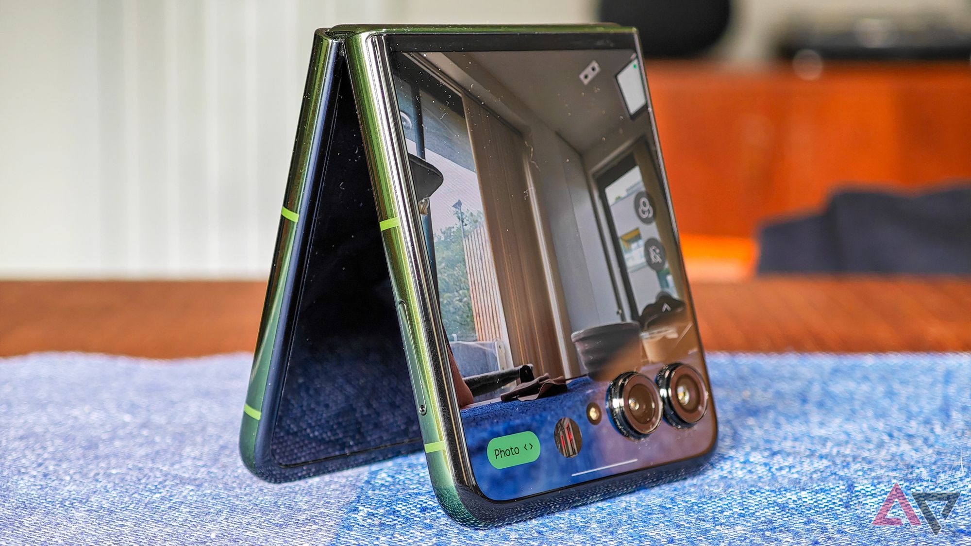 Motorola Razr+ 2024 resting on a blue tablecloth in a tent position showing the camera feed on the cover screen