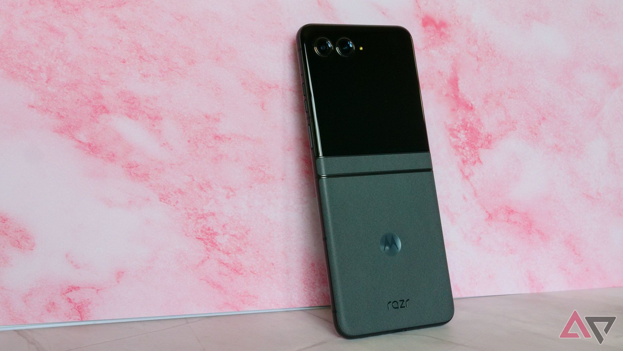 The Moto Razr 2024 leaning against a pink backdrop.