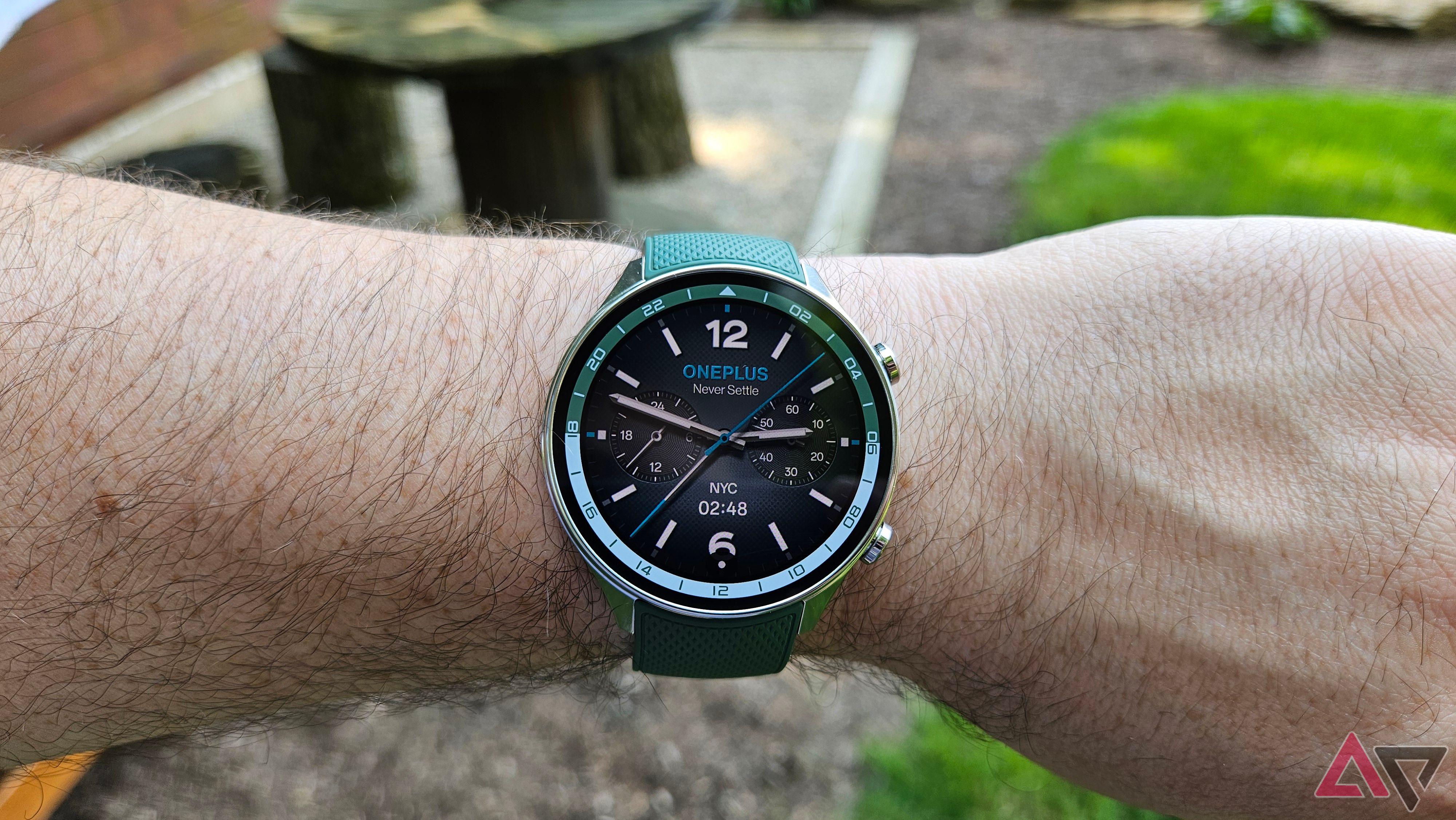 OnePlus Watch 2R in Forest Green with analogue watch face on a wrist.