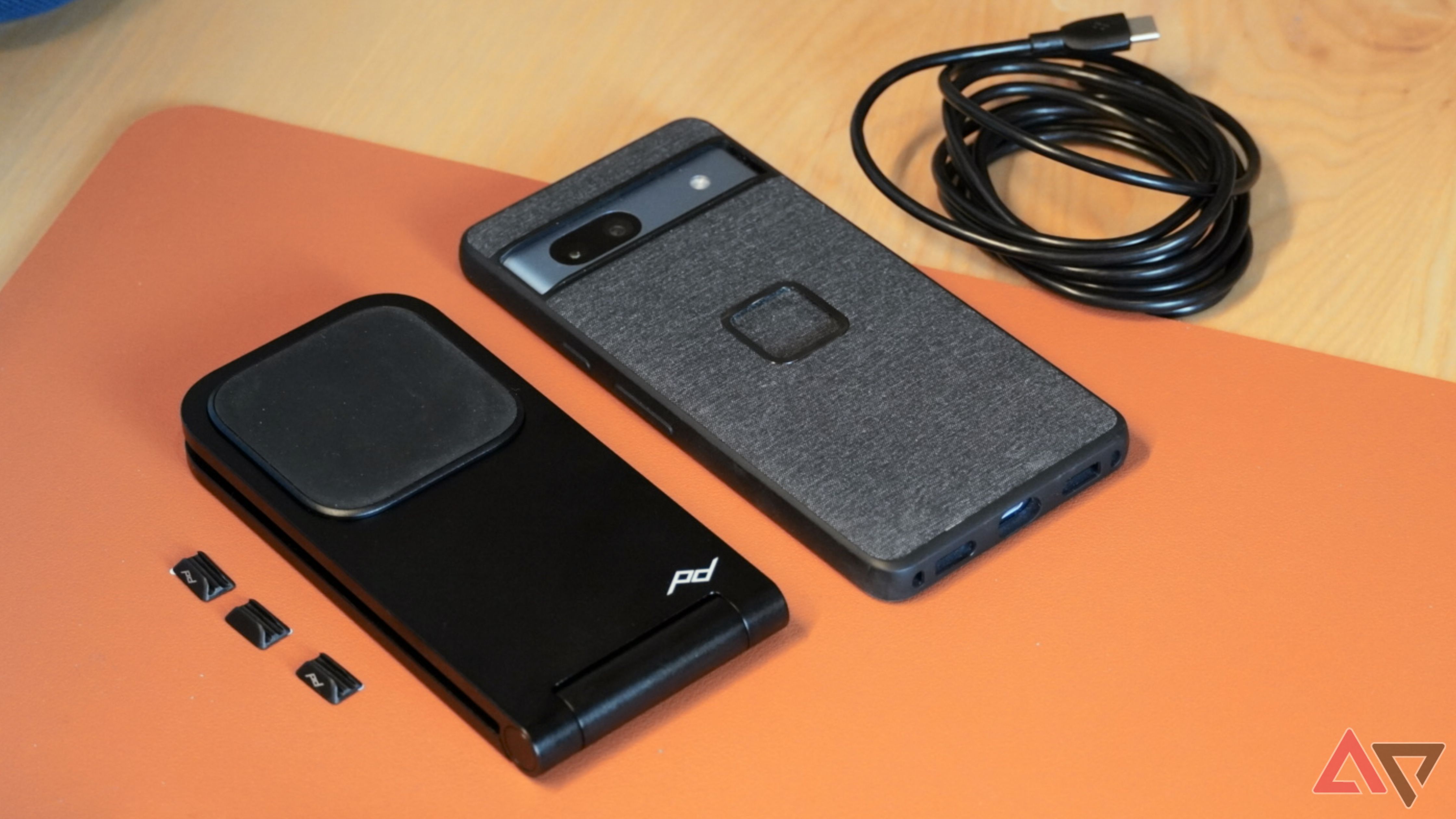 A spread of the Peak Design wireless charger with a Peak Design case.