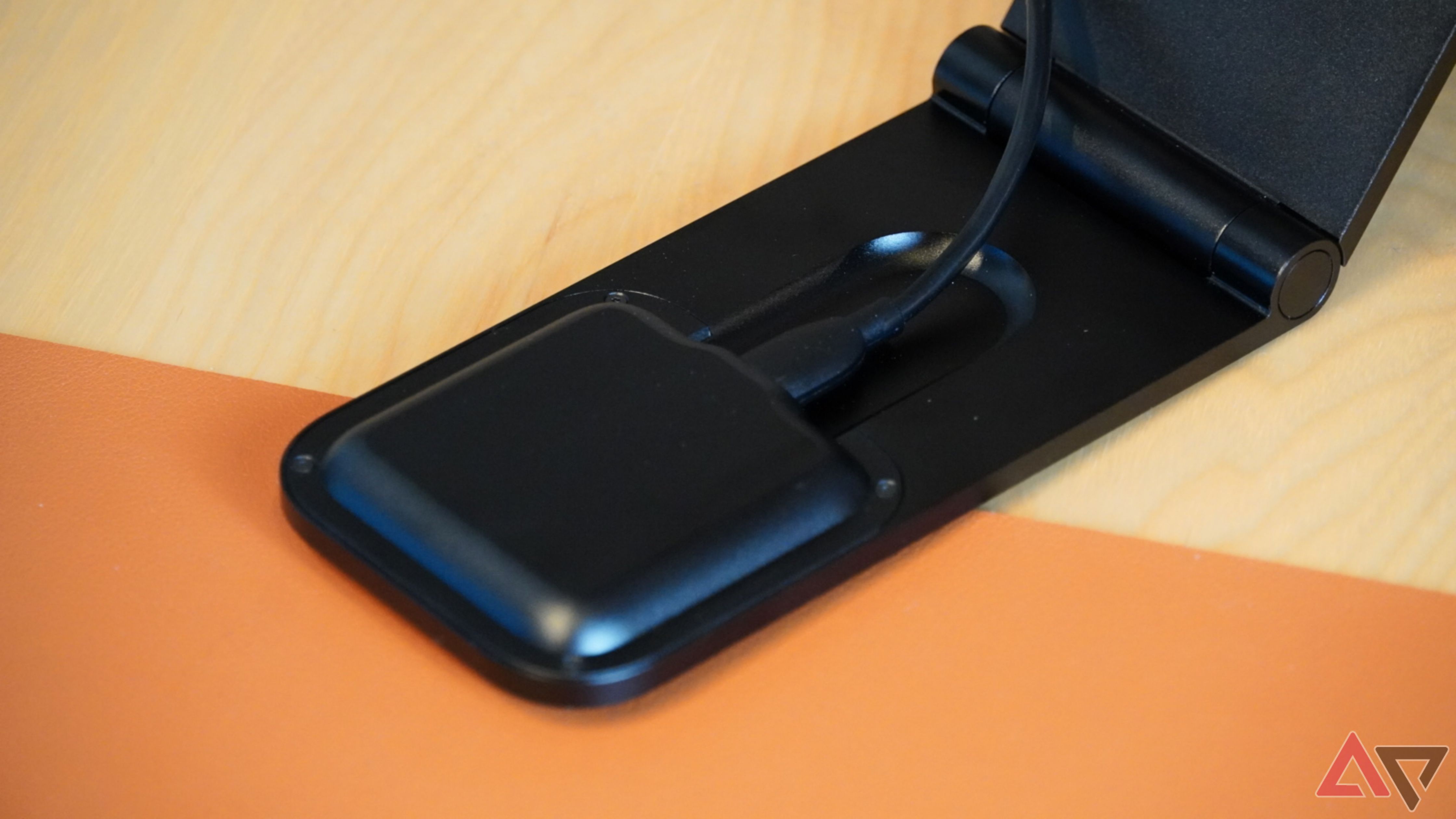 The USB-C cord plugging into the Peak Design wireless charging stand.