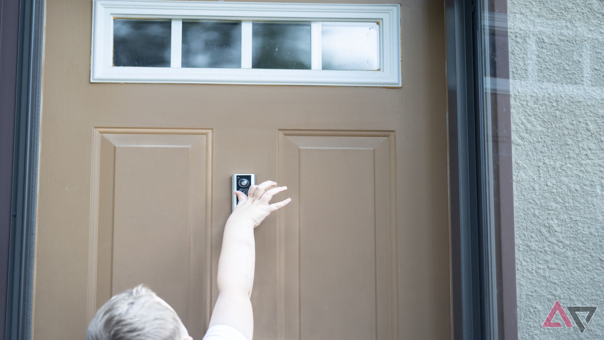 Young boy ringing doorbell on Ring Peephole Cam