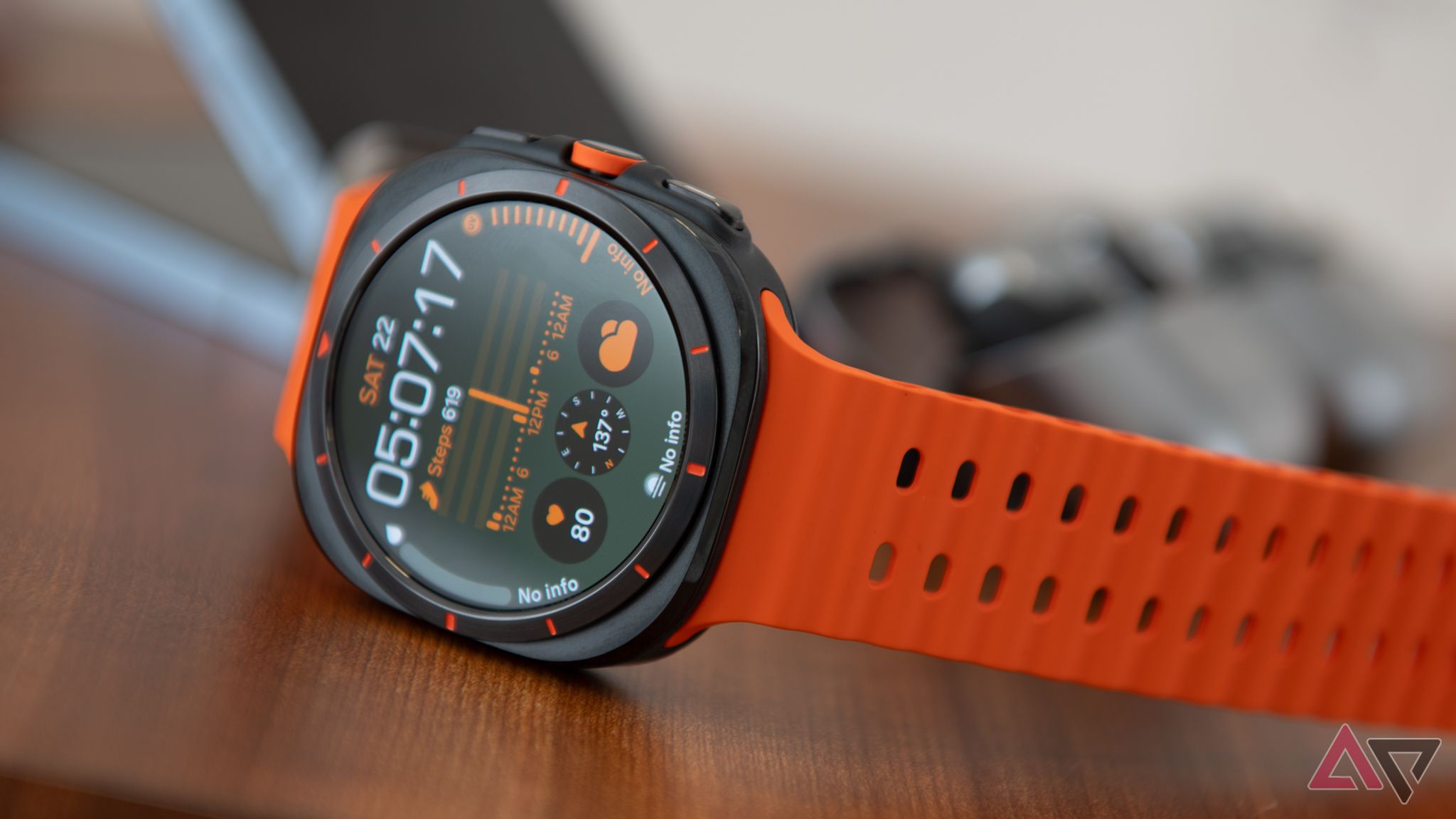 An orange Galaxy Watch Ultra resting on a desk